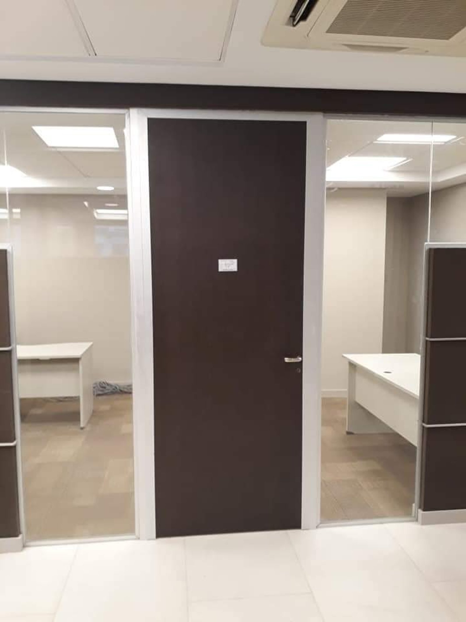 Puerta de oficina oscura con paredes de cristal y escritorio — proyecto Banco Galicia divisores, por Cristalcenter, en Maipú