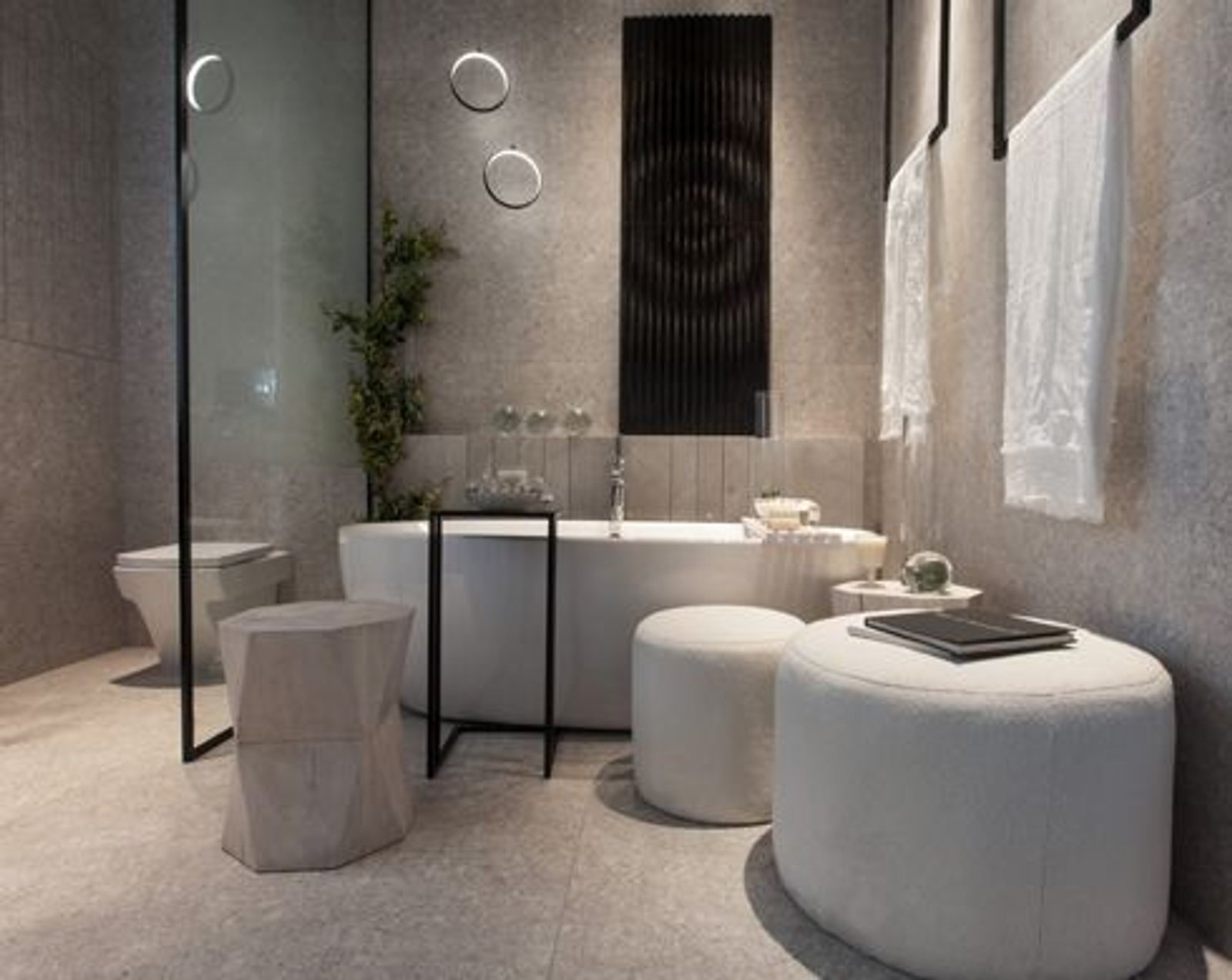 Banheiro moderno com banheira freestanding e detalhes em pedra cinza — projeto Casa Foa Retiro 2022, por Vite Porcellanato, em Buenos Aires