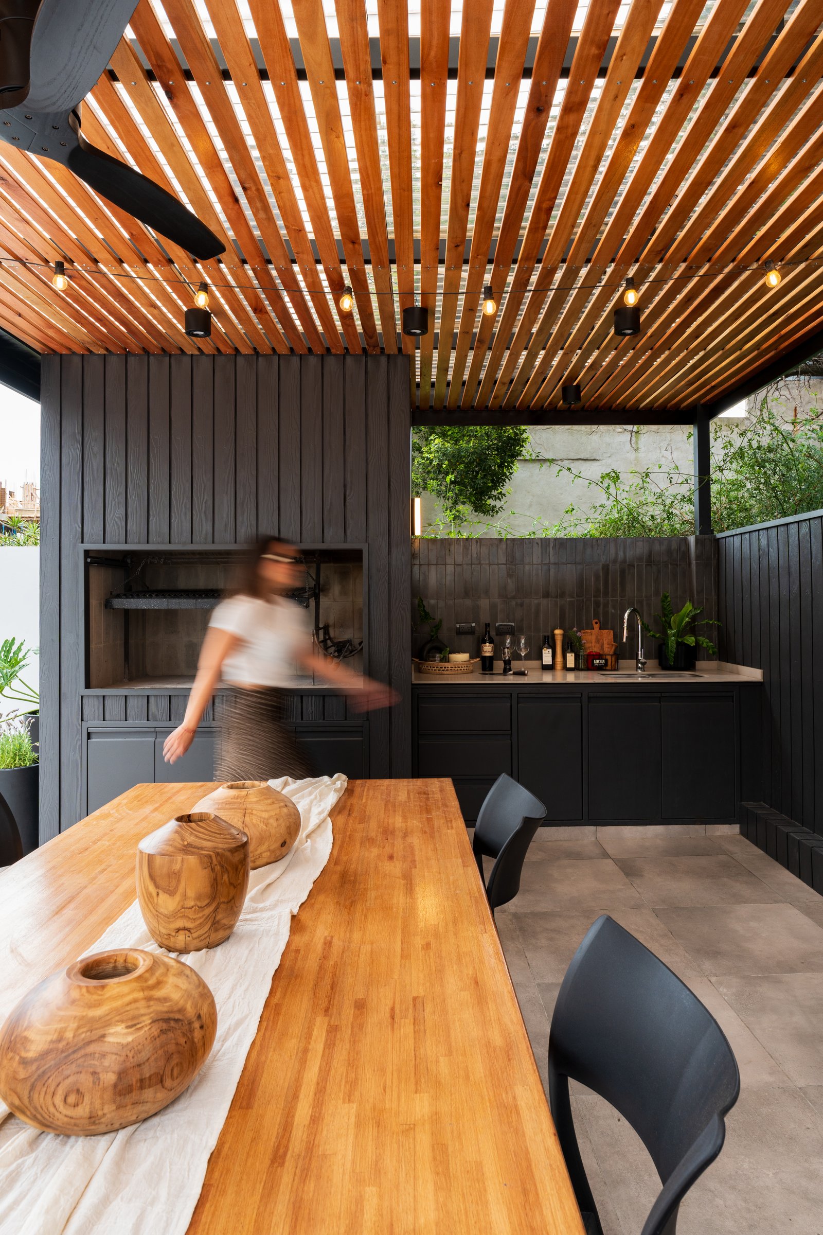 Comedor y cocina exterior con pérgola de madera y isla — proyecto TERRAZA MARCOS SASTRE, por FARQ ESTUDIO, en Villa del Parque