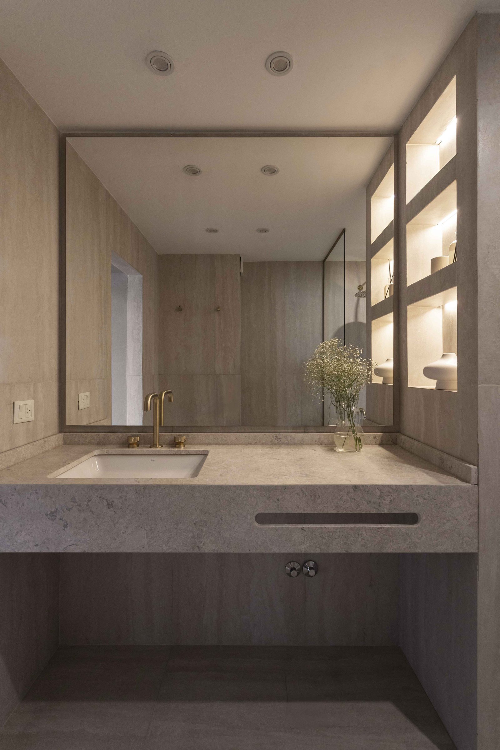 Banheiro moderno com bancada de pedra, cuba e torneira dourada — projeto Libertador, por Bouré Studio, em Palermo