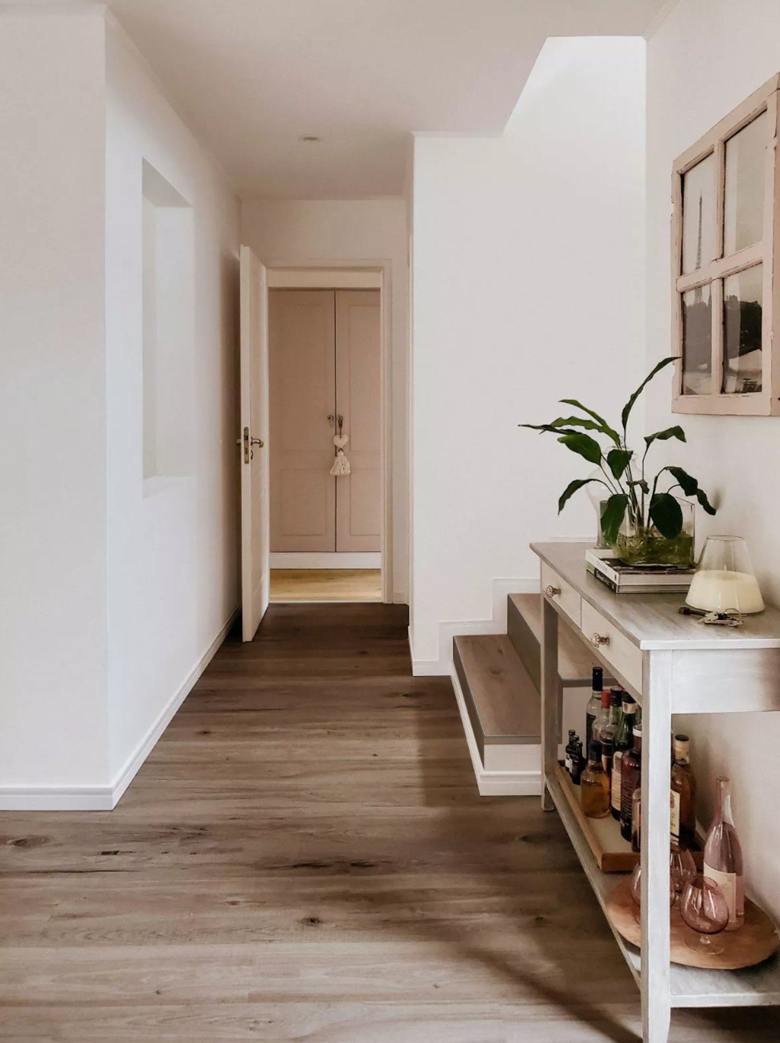 Corredor moderno com piso de madeira, console com bar e planta alta — projeto Vanguardia y Distinción en el diseño interior., por ATRIM GLOBAL, em Buenos Aires