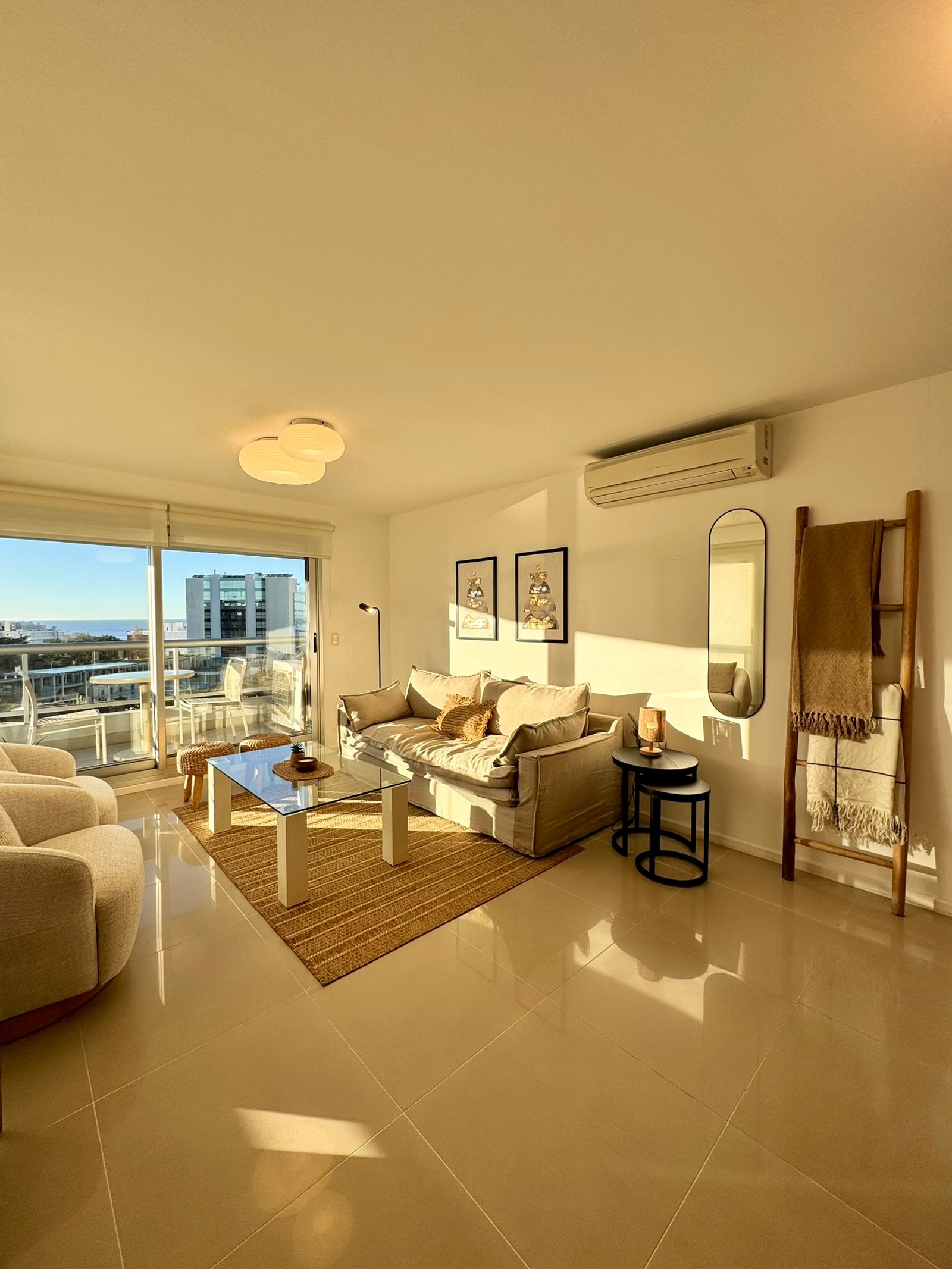 Sala de estar moderna com sofá modular e muita luz natural — projeto Quartier Punta del Este, por MDBK Arquitectura, em Punta del Este
