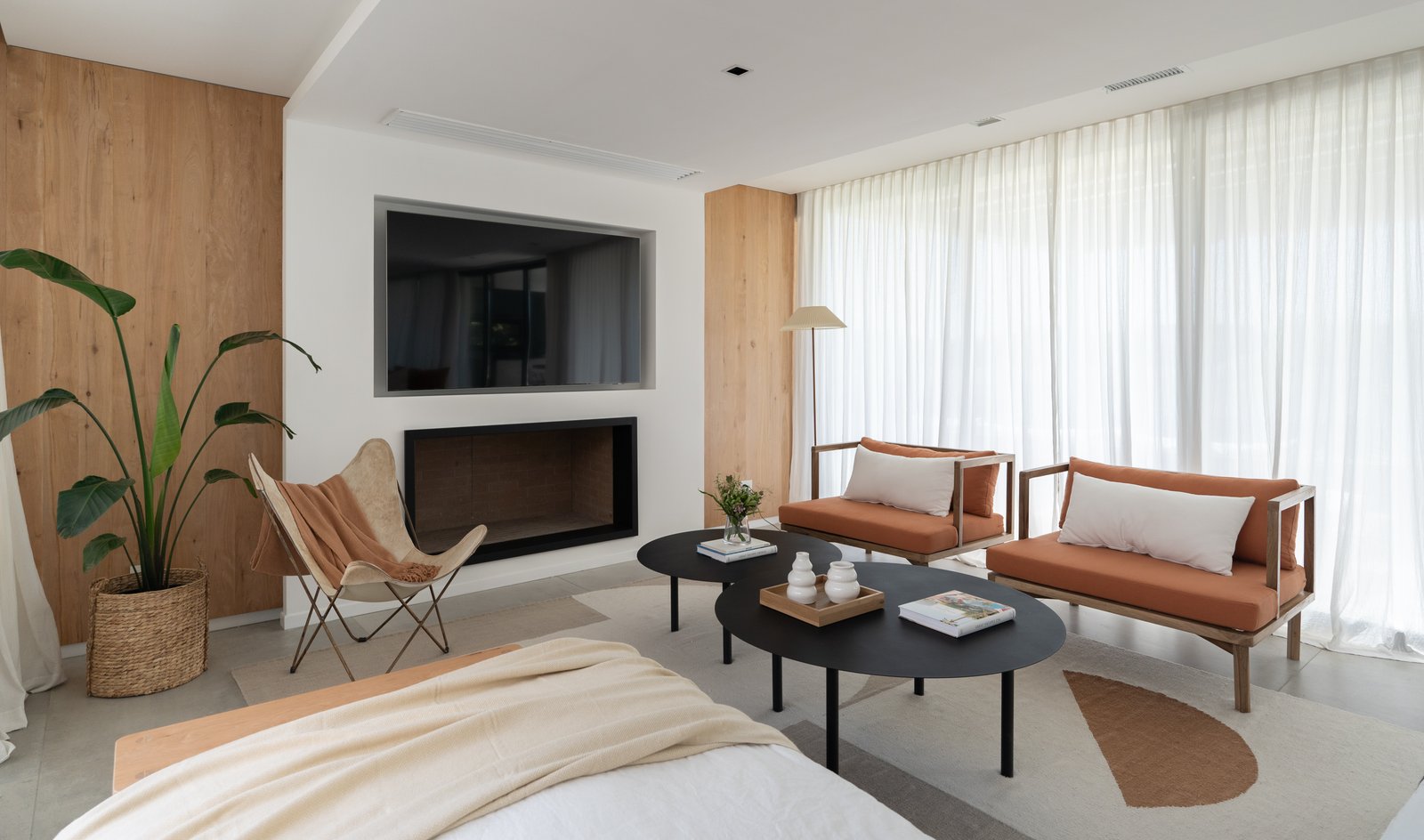 Sala de estar moderna com parede de madeira, lareira e móveis confortáveis — projeto PROYECTO VISTAS, por July Acosta Home, em Belén de Escobar