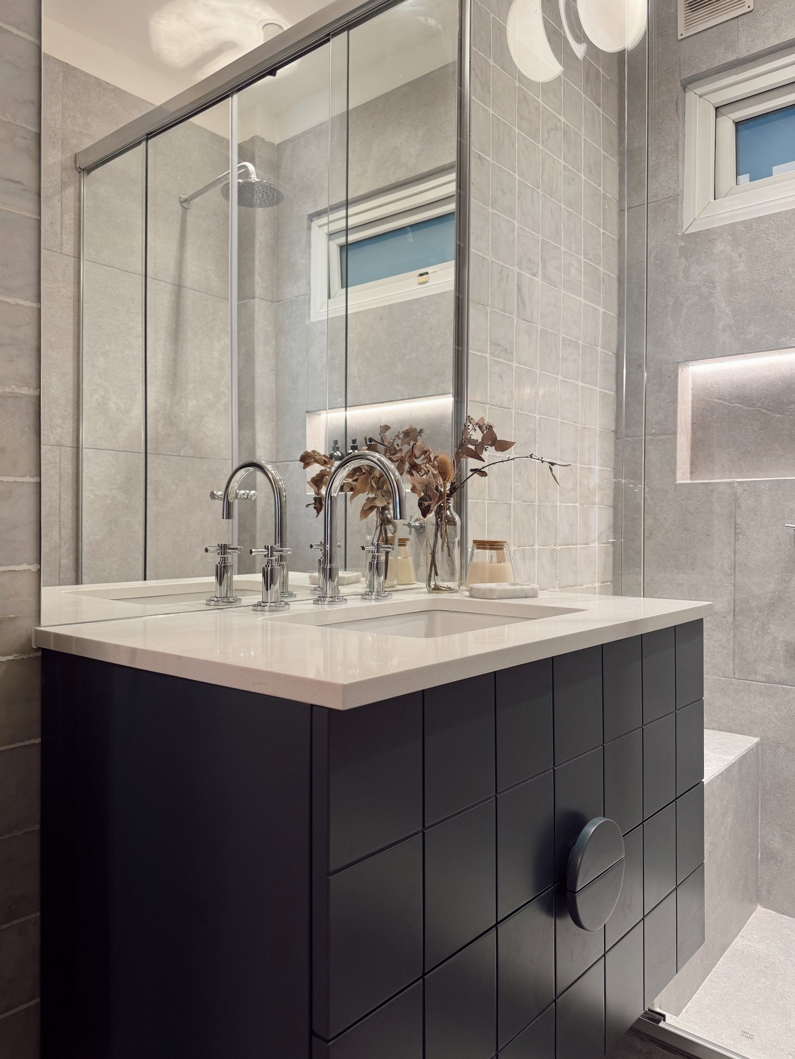 Baño moderno con vanitory negro, mesada de piedra y grifería cromada — proyecto Virrey Loreto, por Estudio BDM, en Buenos Aires