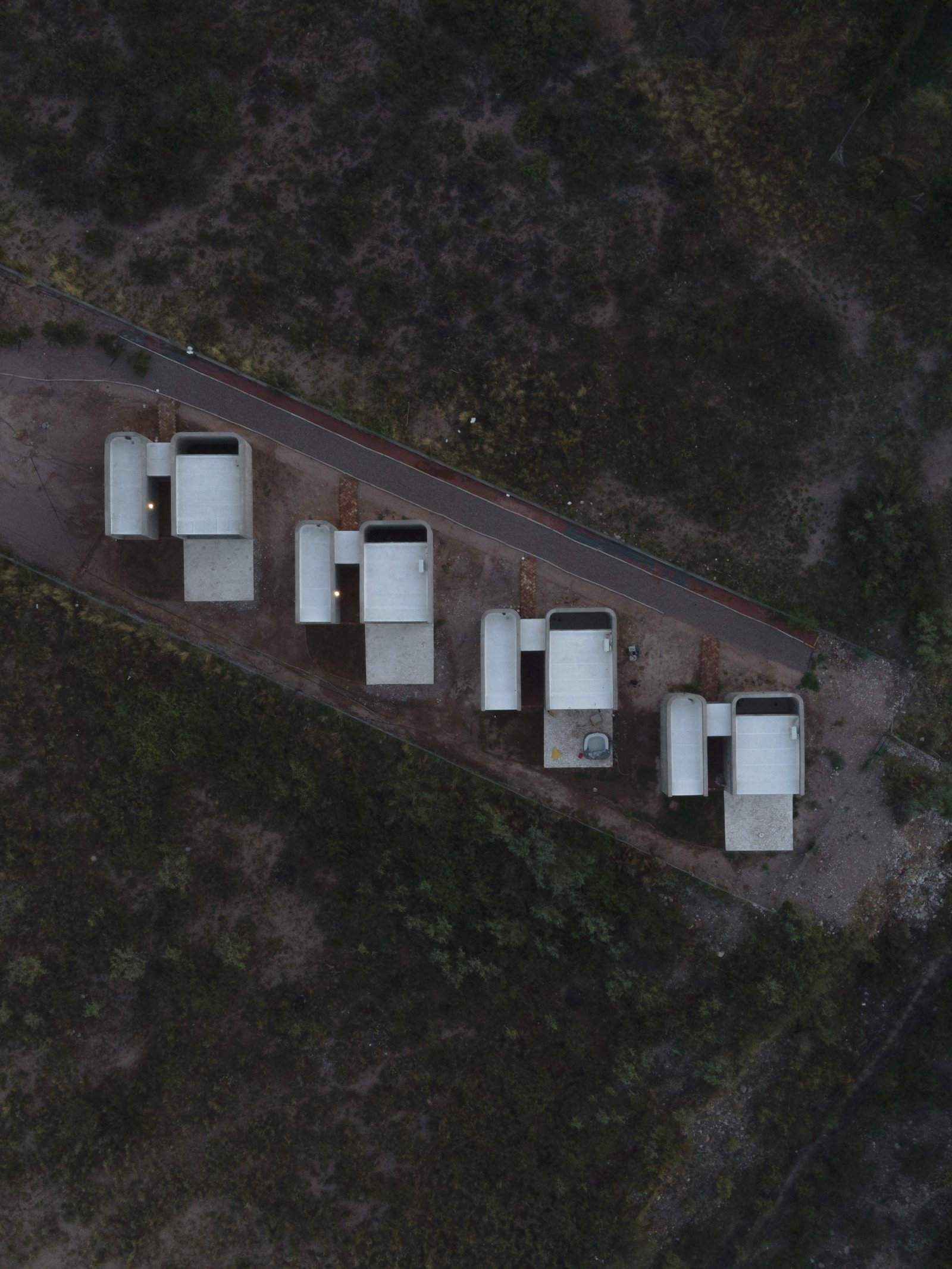 casas modernas de hormigón apilado en entorno árido — proyecto Complejo SCV, por ONA - Oficina Nómada de Arquitectura, en Las Compuertas