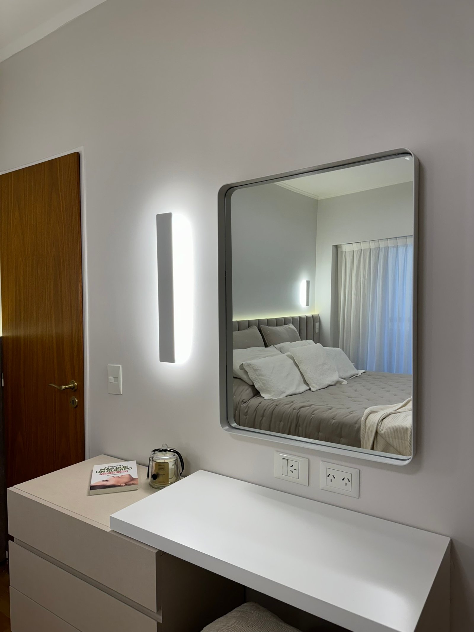 Dormitorio moderno con tocador minimalista y lámpara lineal — proyecto Thompson, por MDBK Arquitectura, en Caballito