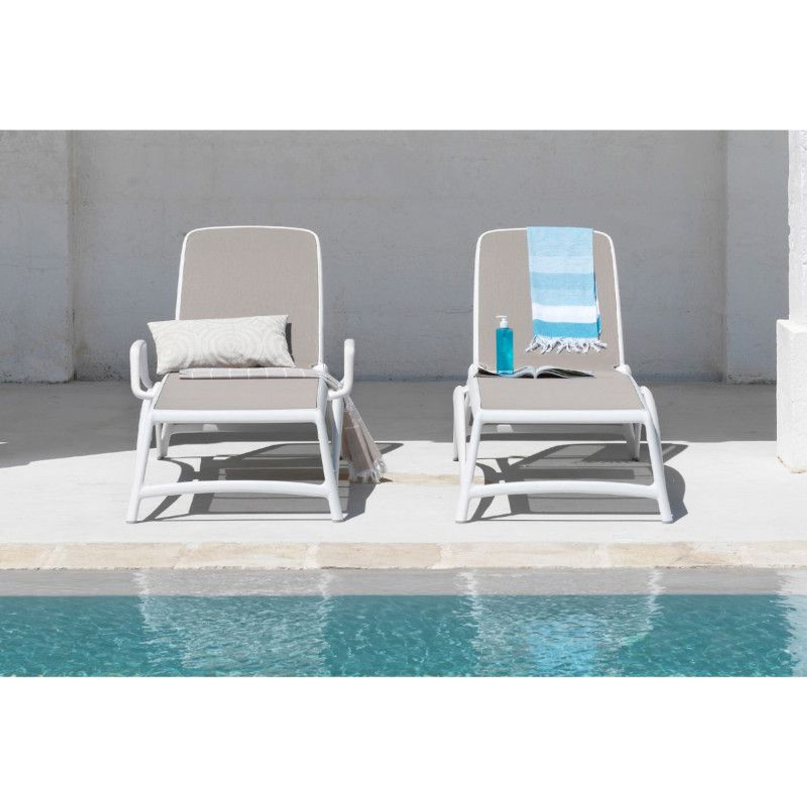 Duas espreguiçadeiras minimalistas ao lado de uma piscina — projeto Reposeras NARDI®, por Casa Nuñez