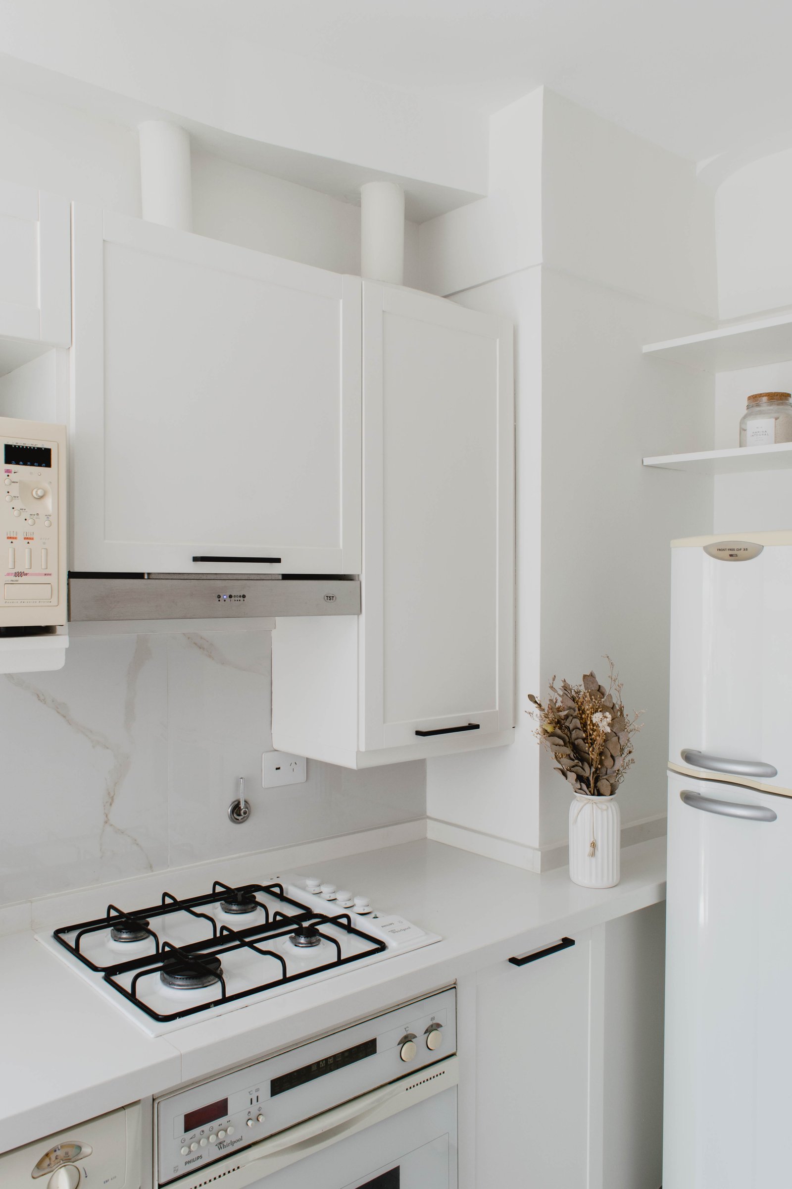 Cozinha minimalista branca com geladeira retrô e fogão a gás — projeto Goyena, por Martina Kleinert, em Caballito