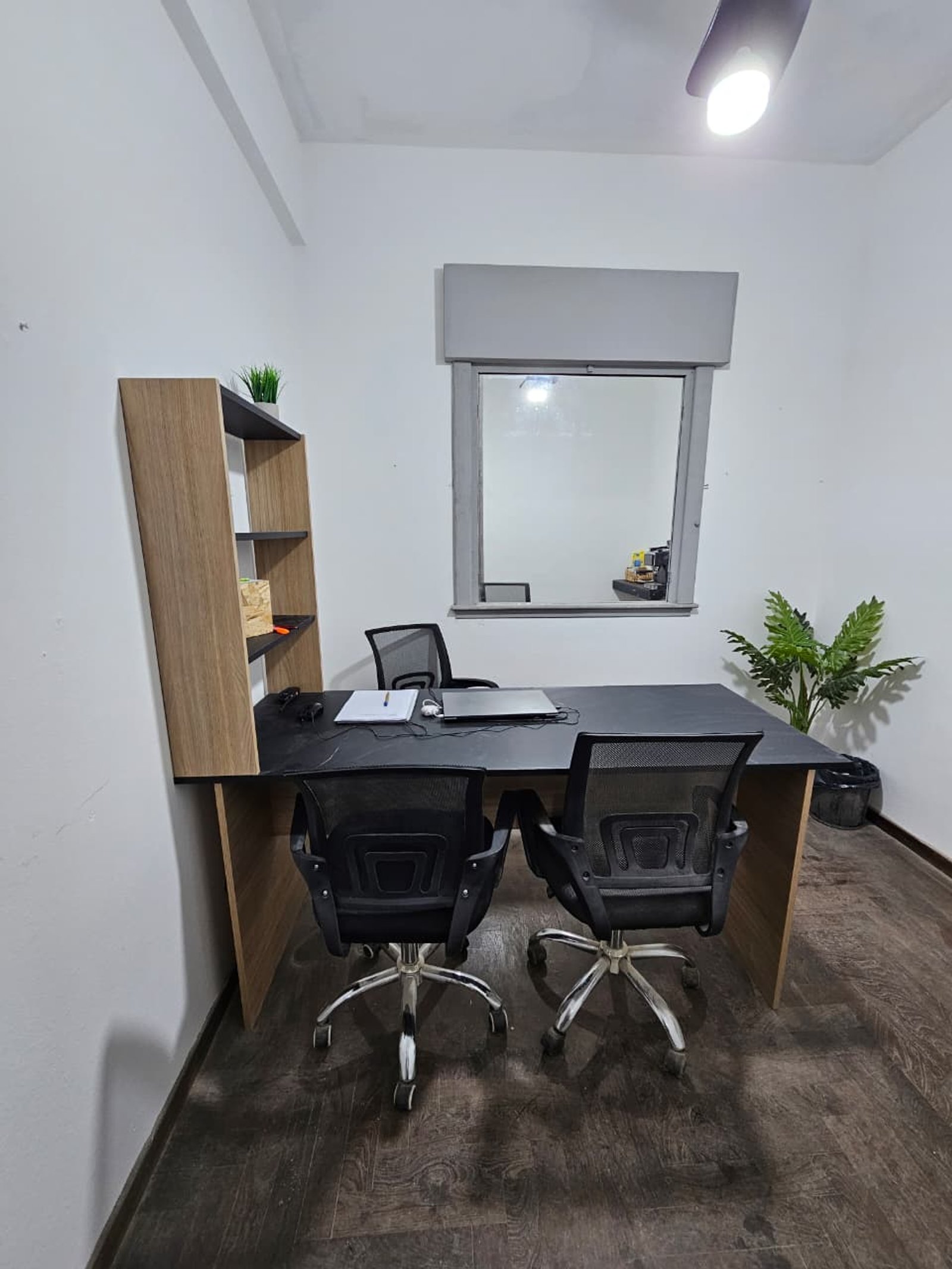 Escritório moderno com mesa preta e cadeiras ergonômicas — projeto Proyecto DA, por D'Agostina, em B1663 San Miguel