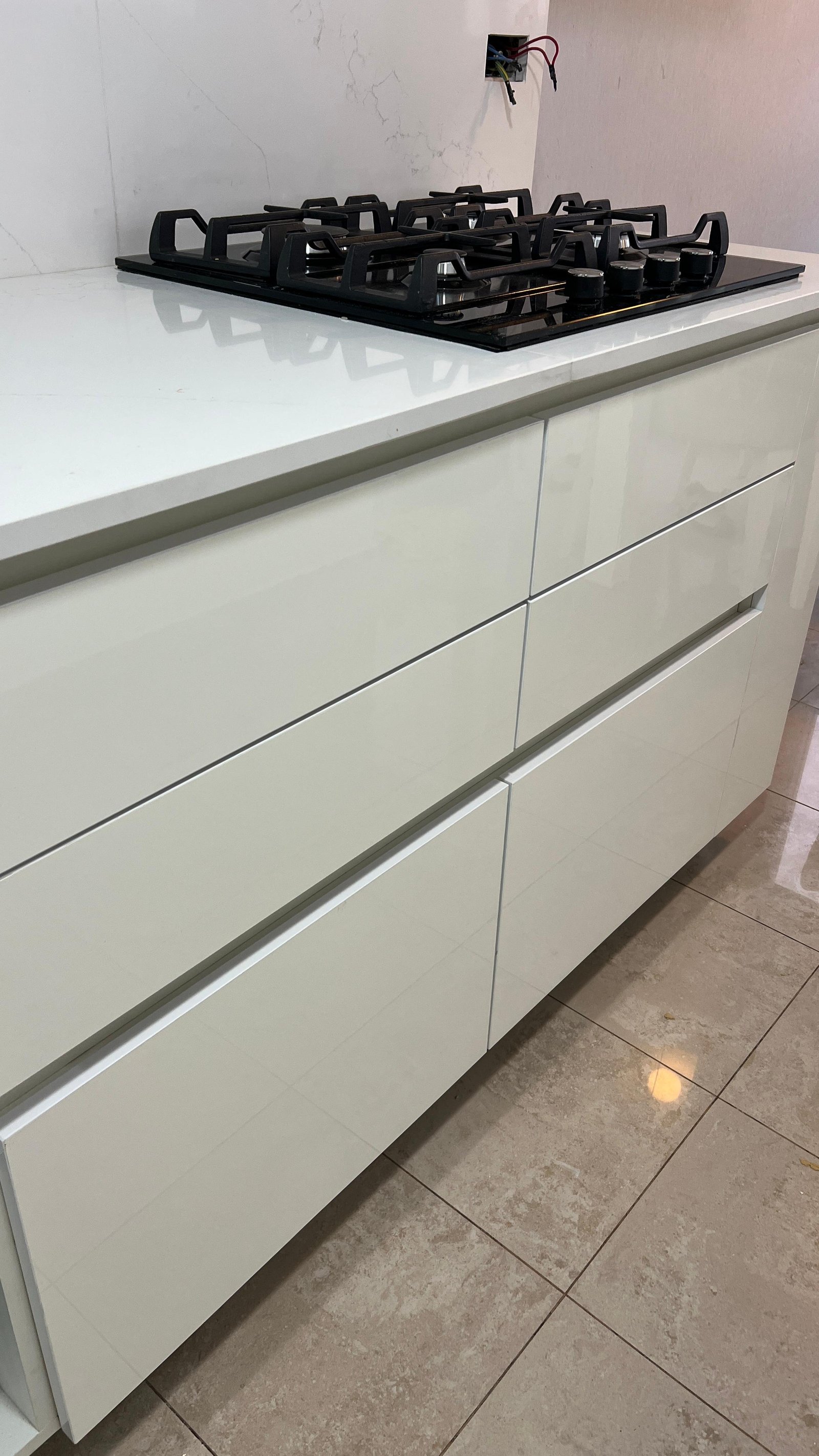 Cocina moderna con muebles blancos y anafe a gas empotrado — proyecto Cocina con frentes en rousbicio blanco , por Carpinteria Tientta, en Puerto Madero