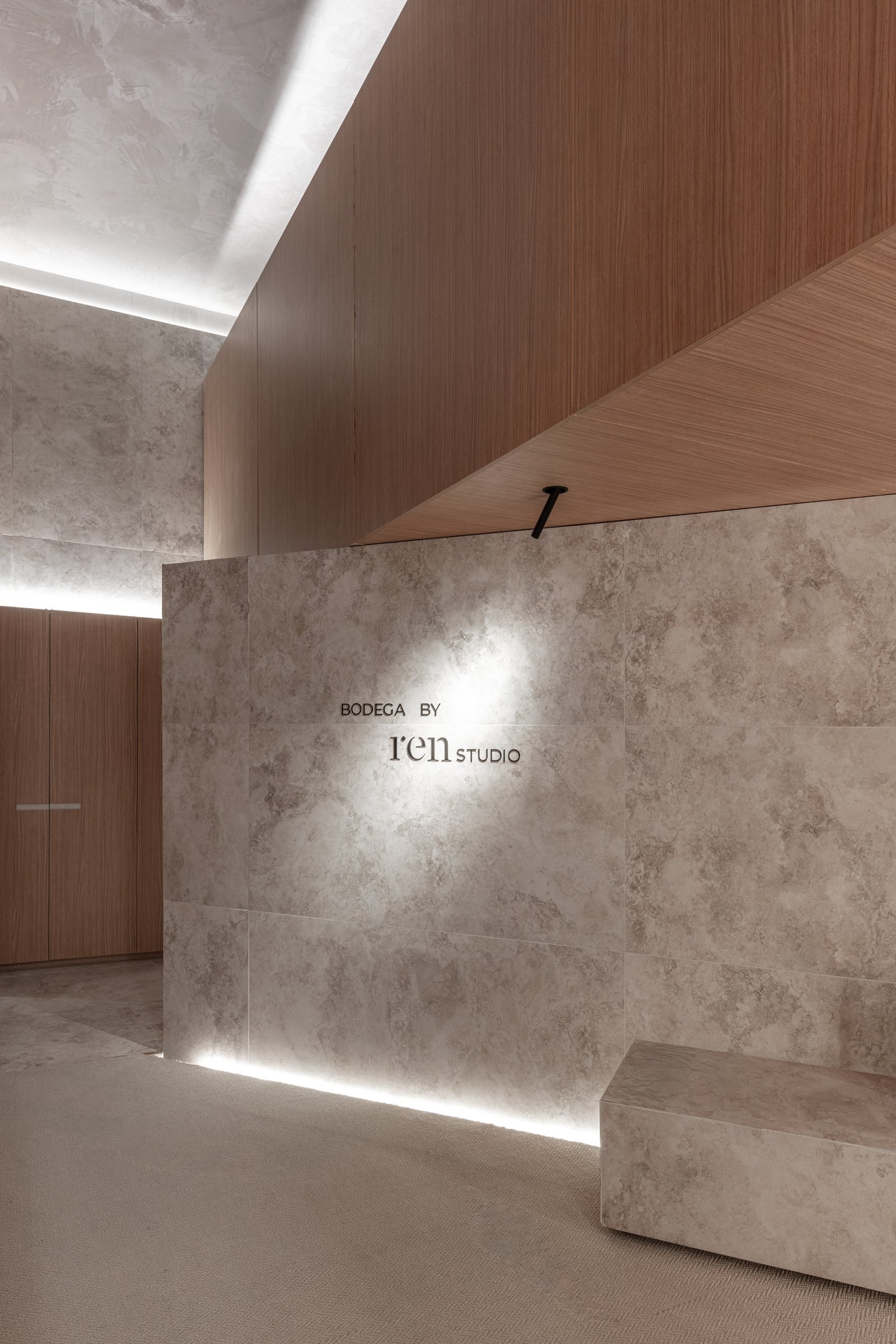 Recepción moderna con paredes de piedra y detalles en madera y luces — proyecto Casa Foa 2025 | Degustando experiencias | Tasting experiences | Lucia Quinteros, por Ren Studio, en 