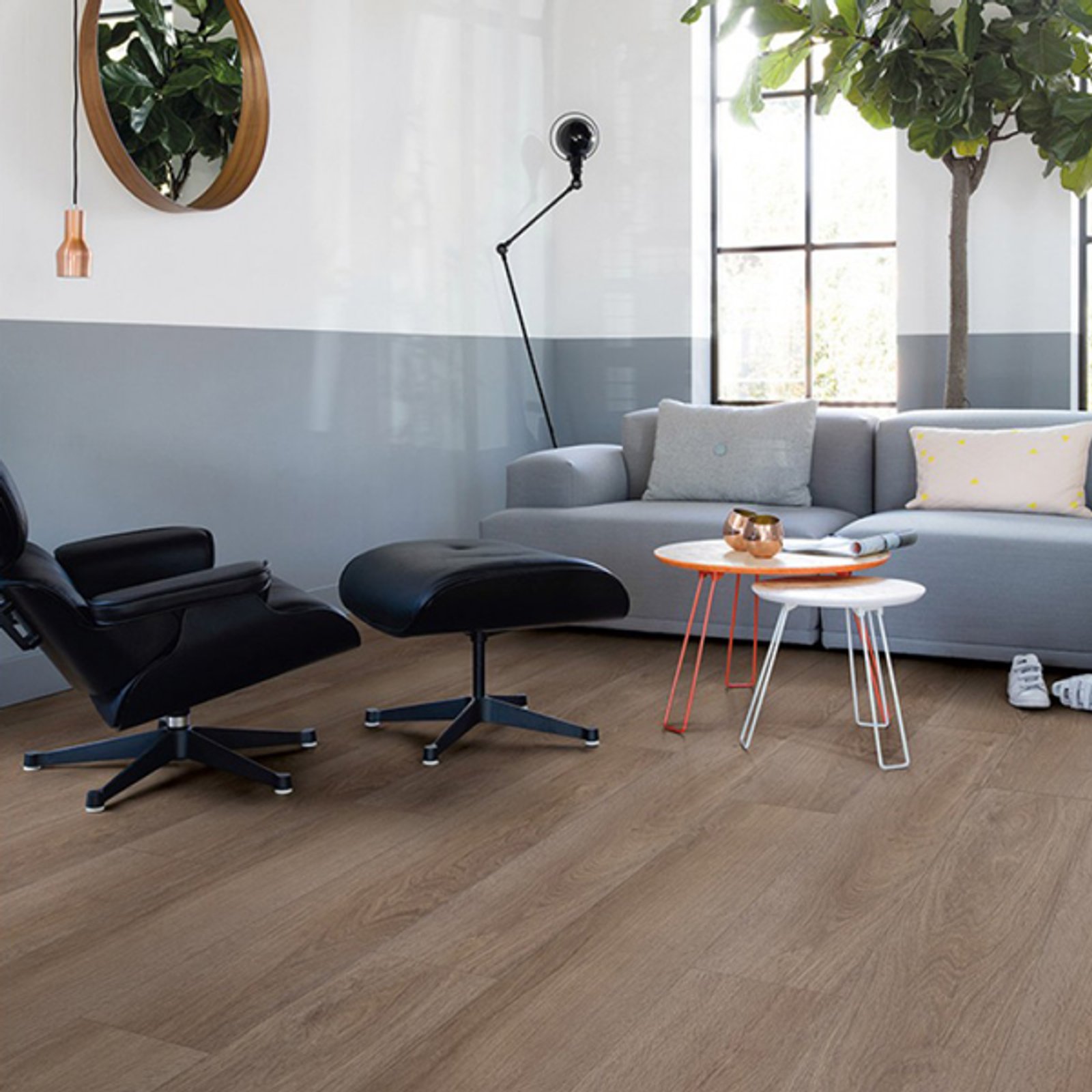 Living moderno con sillón negro curvo y mesas redondas — proyecto Pisos Vinílicos, por The Flooring Company