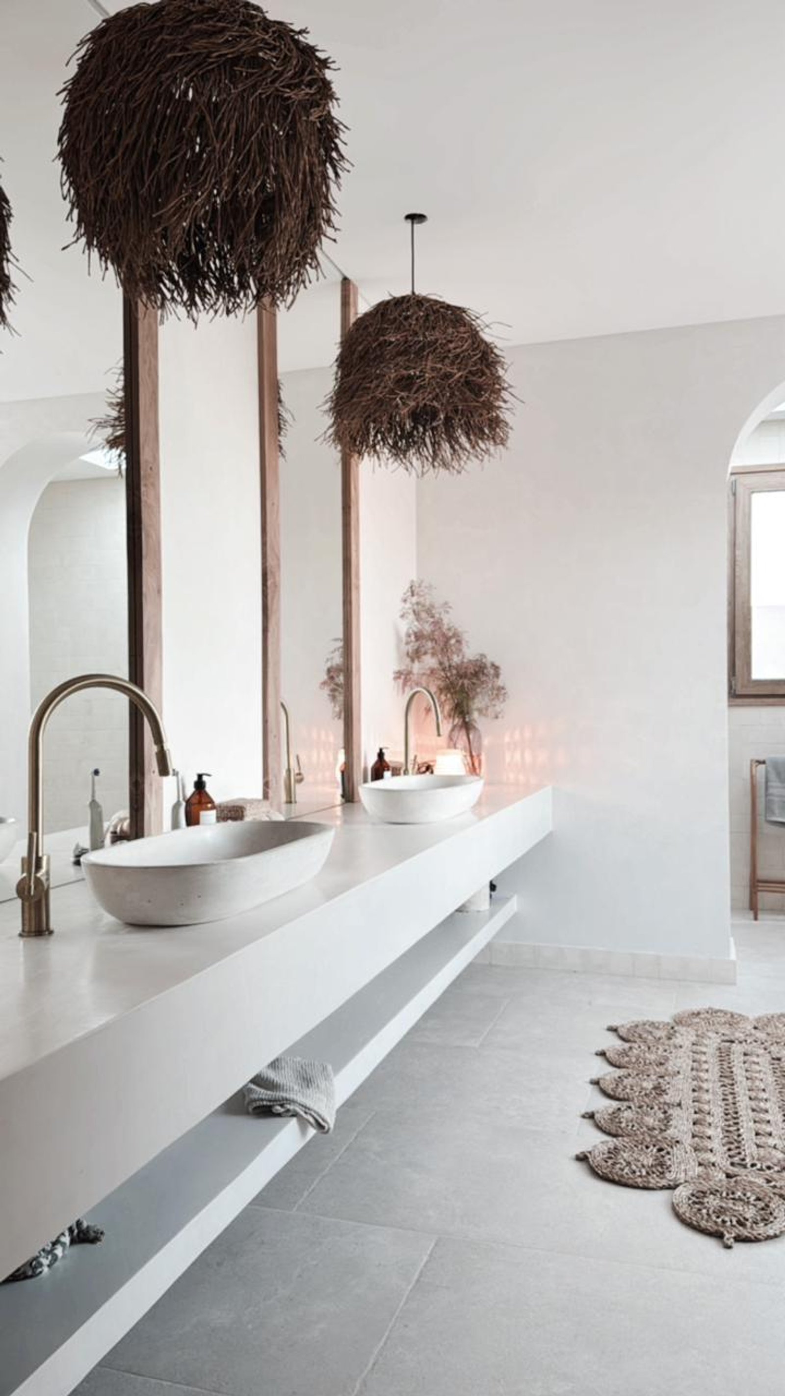 Baño estilo mediterráneo con lavabos de piedra y lámparas de mimbre — proyecto OBRA EL REFUGIO, por ILVA, en Provincia de Buenos Aires