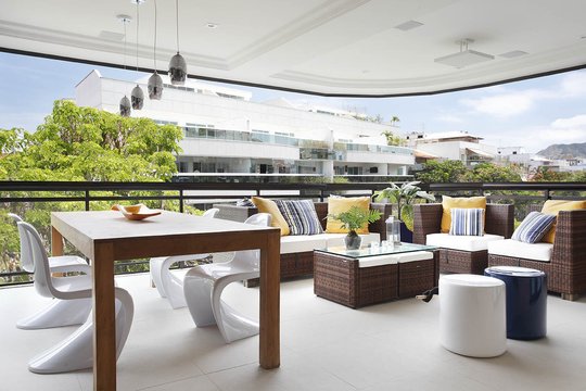 Terraza moderna con vistas a la ciudad, muebles de diseño y plantas — proyecto Apartamento Recreio, por Amanda Miranda