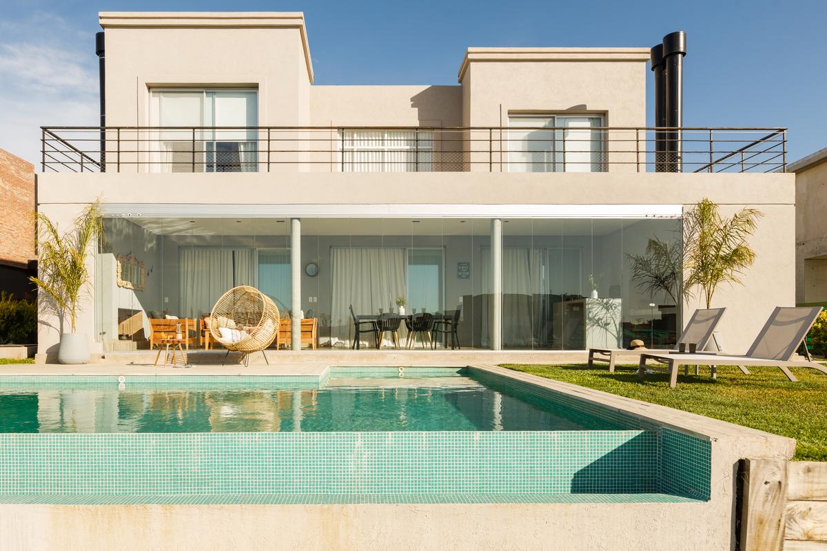 Casa moderna com piscina, móveis externos e cadeira suspensa — projeto TOLDER - CERRAMIENTOS, por Argentina en Obra 2024, em Rincón de Milberg