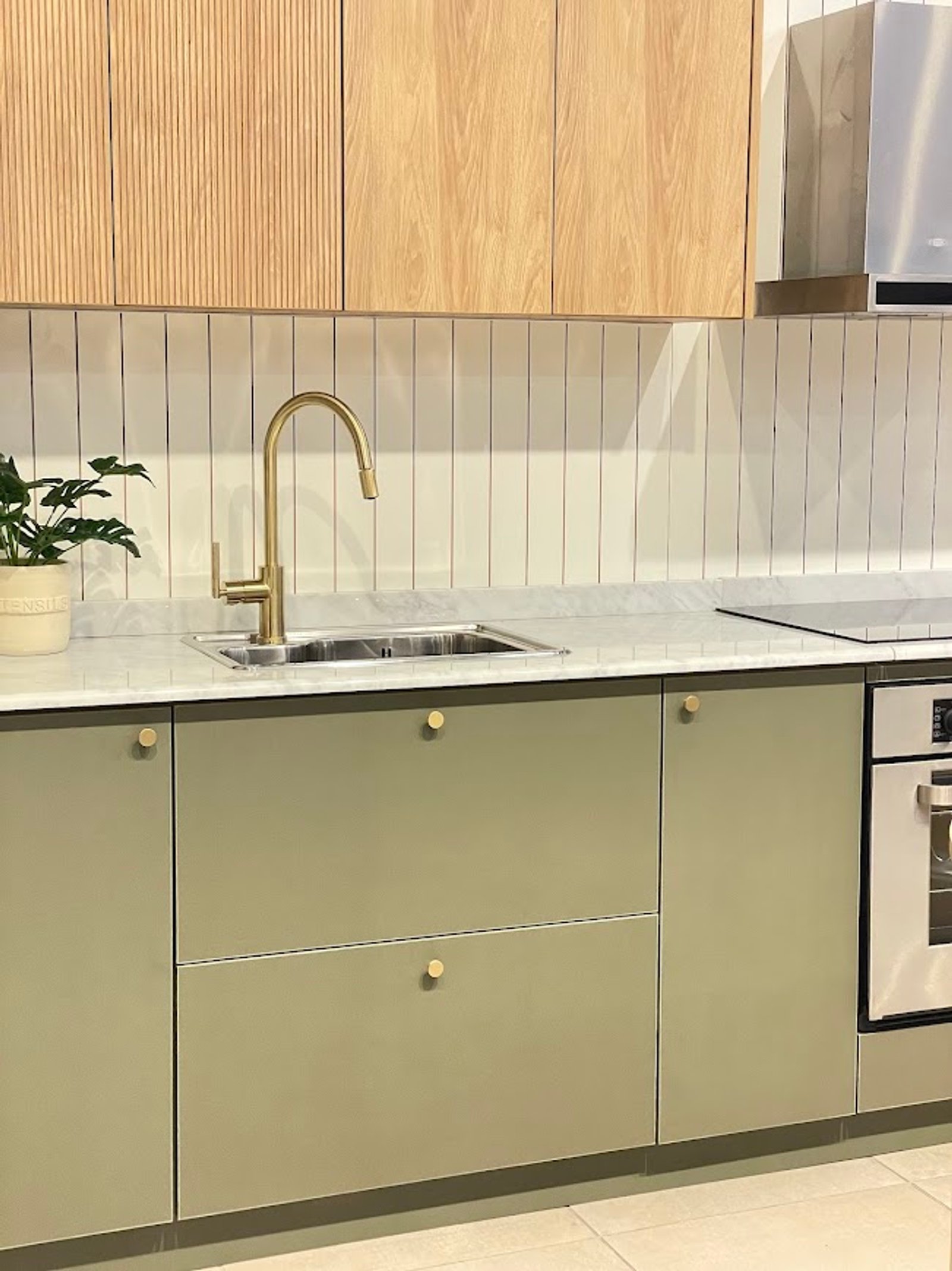 Cocina moderna escandinava con gabinetes de roble y grifería de latón — proyecto Línea Valencia, por Casa Leiro