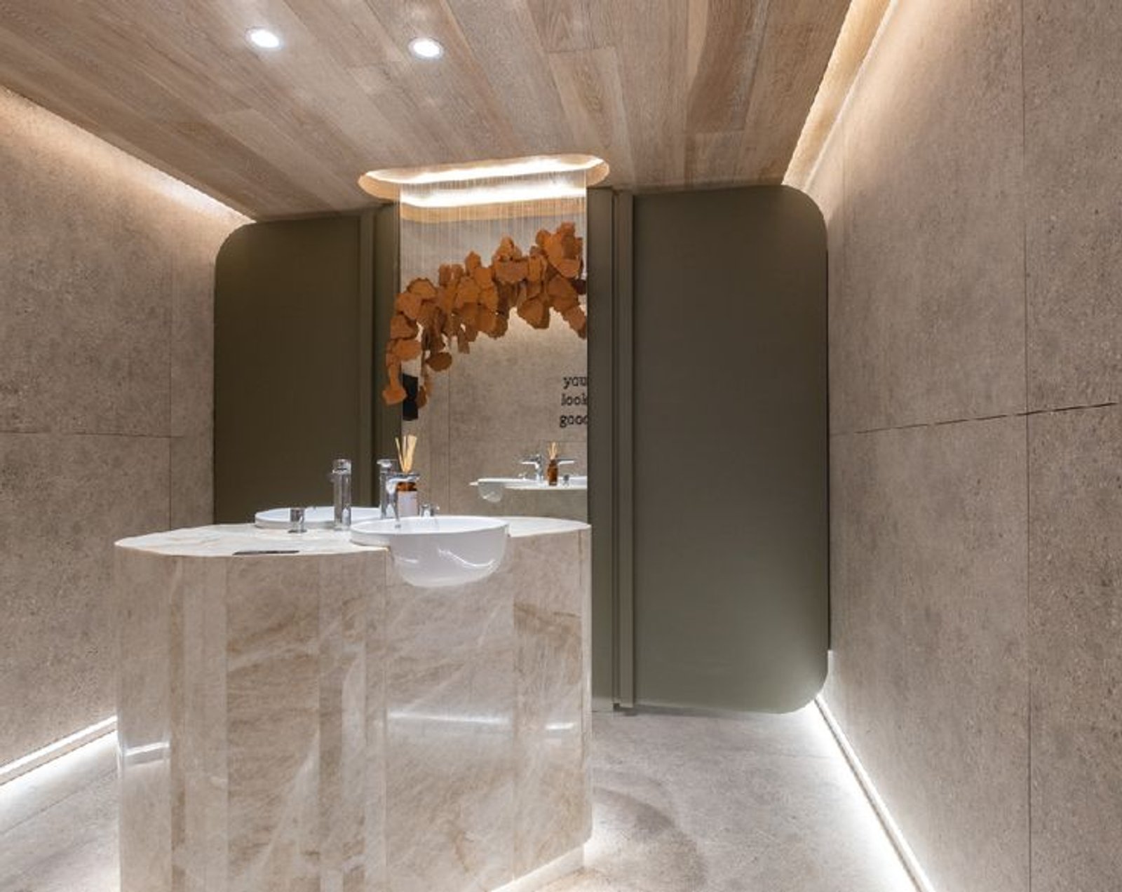 baño de hotel con lavabo curvo y revestimientos en piedra — proyecto Casa Foa Córdoba 2025, por Vite Porcellanato, en Ciudad de Córdoba