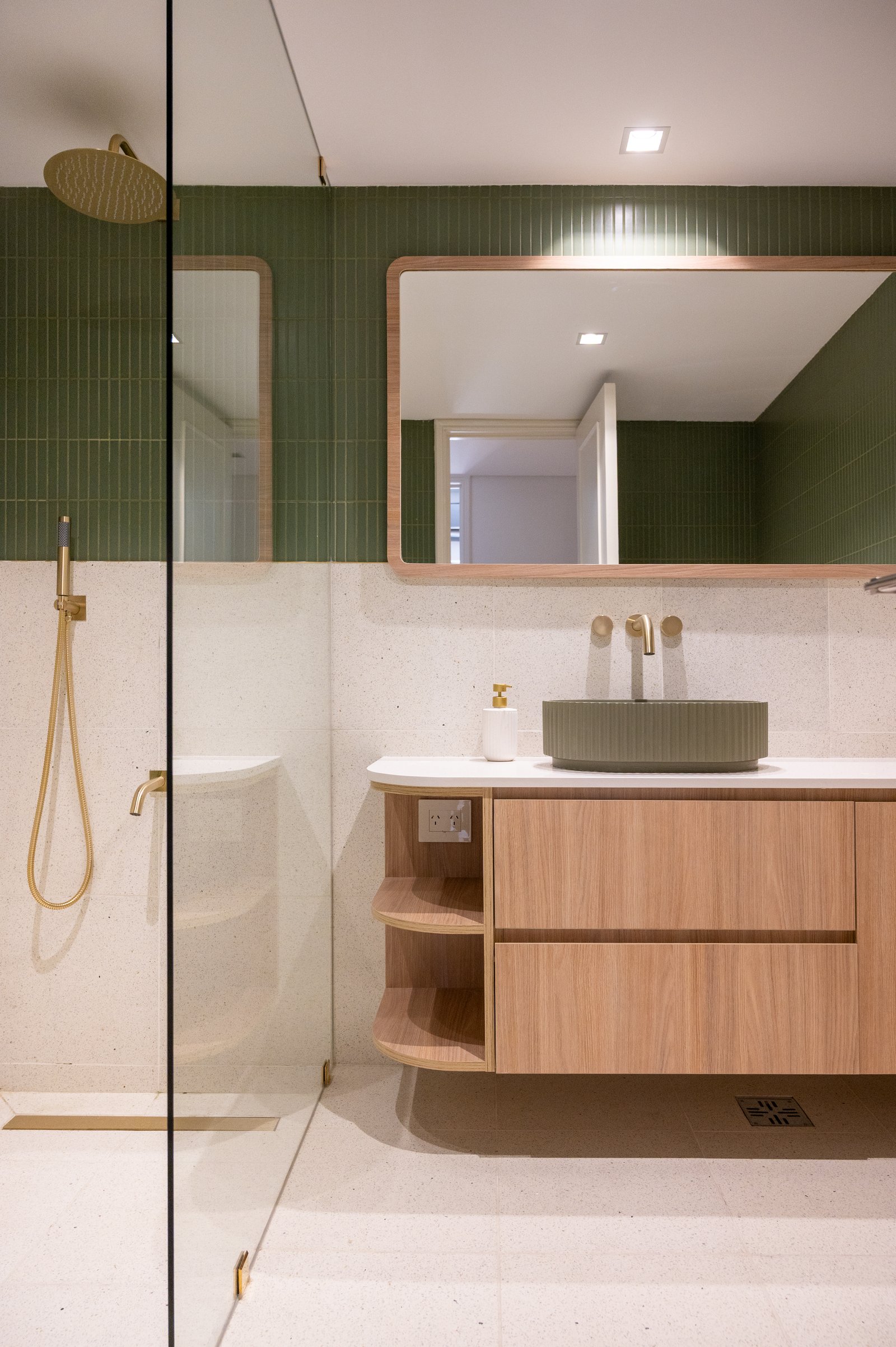 Baño moderno con bacha verde, grifería dorada y mueble de madera — proyecto ALVEAR TYM, por AB ARQUITECTURA, en Recoleta