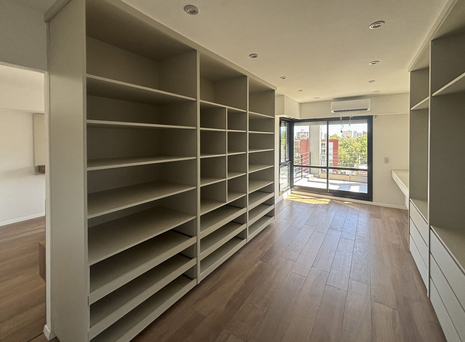 Corredor moderno com prateleiras brancas de parede a parede — projeto EDFICIO DM60, por DIB OBRIST Arquitectas, em Rosario