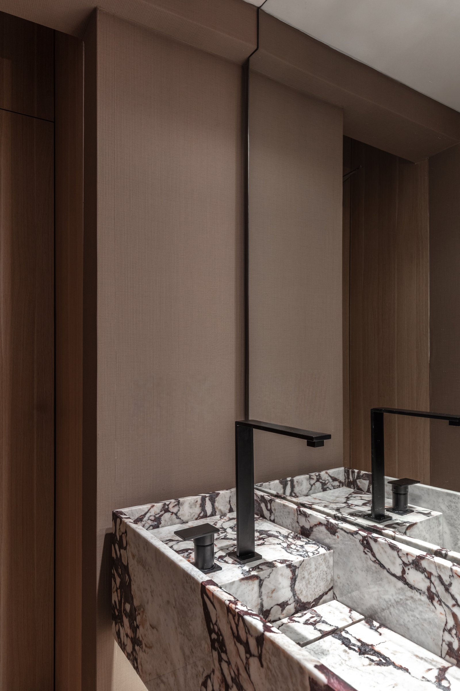 Baño moderno minimalista con lavabos dobles de mármol y grifería negra — proyecto Eslovenia | Pied-à-terre | Lucia Quinteros, por Ren Studio, en Cdad. Autónoma de Buenos Aires