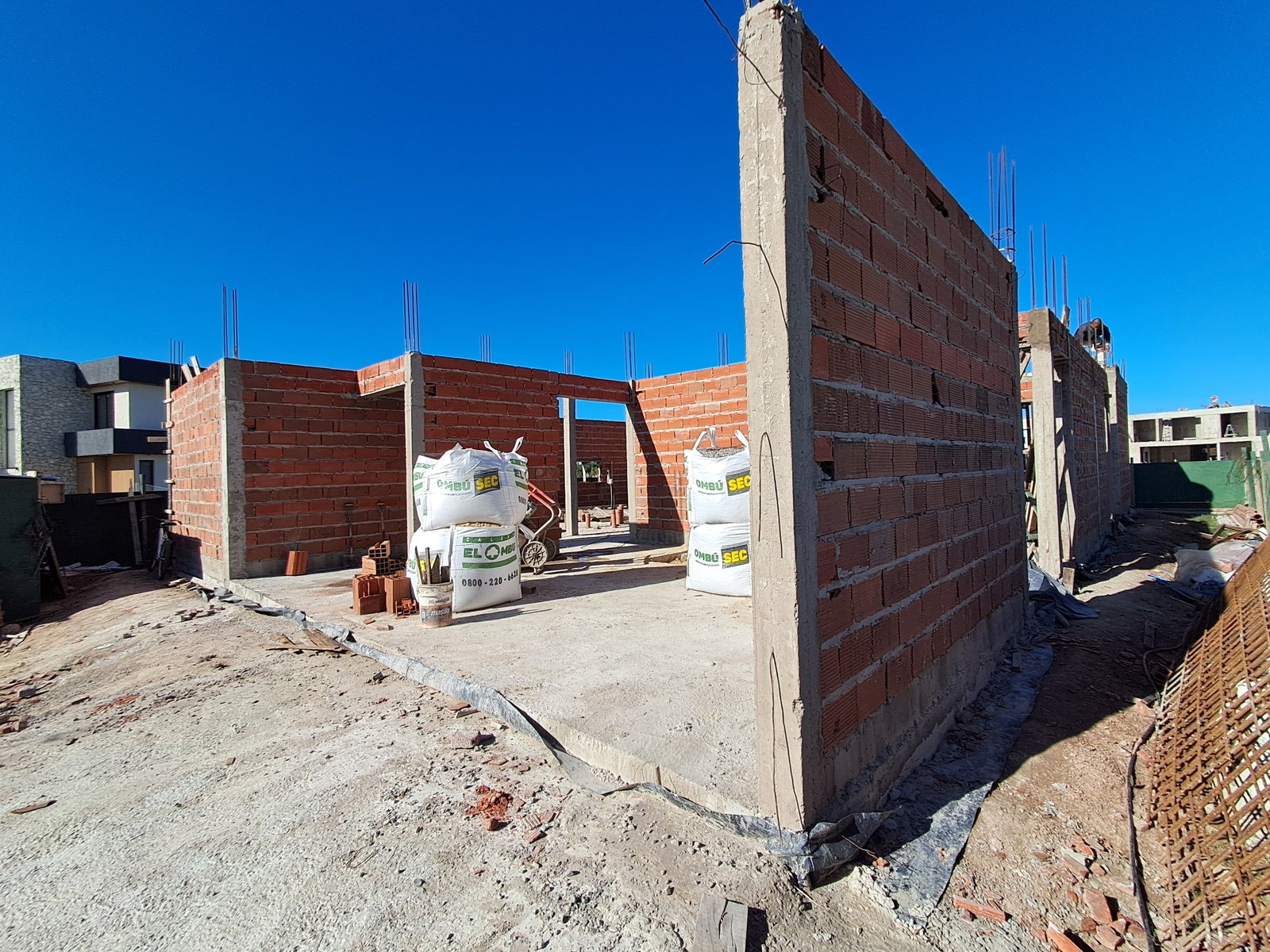 obra en construcción con paredes de ladrillo y bolsas apiladas — proyecto RIBERAS  332, por IRALA CONSTRUCCIONES, en Belén de Escobar