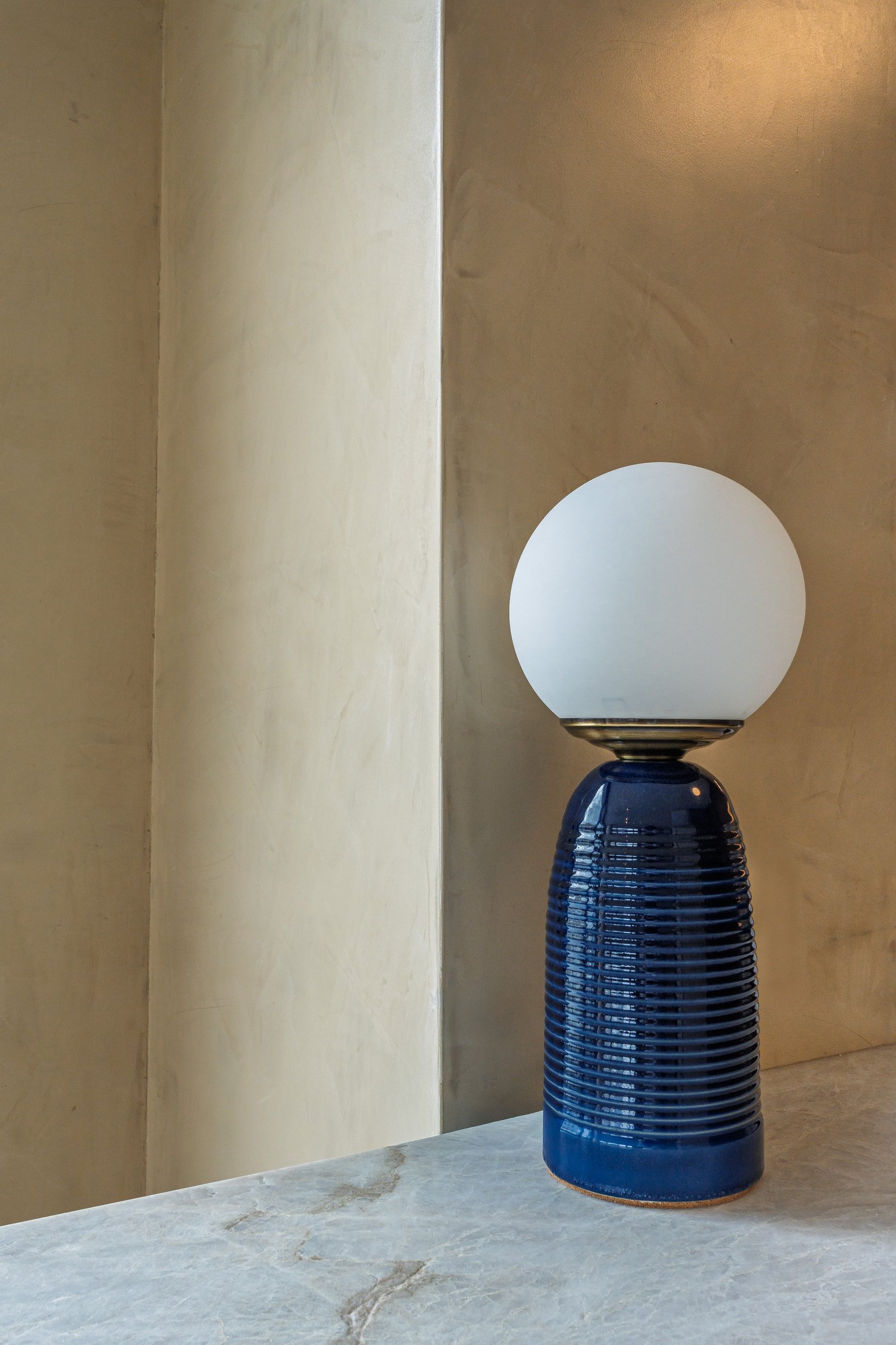lámpara azul de cerámica sobre columna texturada — proyecto Godoy Cruz, por ABEJA CONCEPT, en Palermo