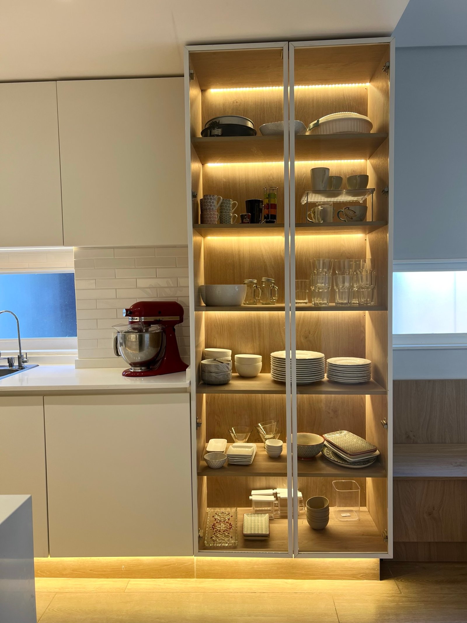 Cozinha moderna com prateleiras de vidro e iluminação quente — projeto Araoz, por MDBK Arquitectura, em Palermo