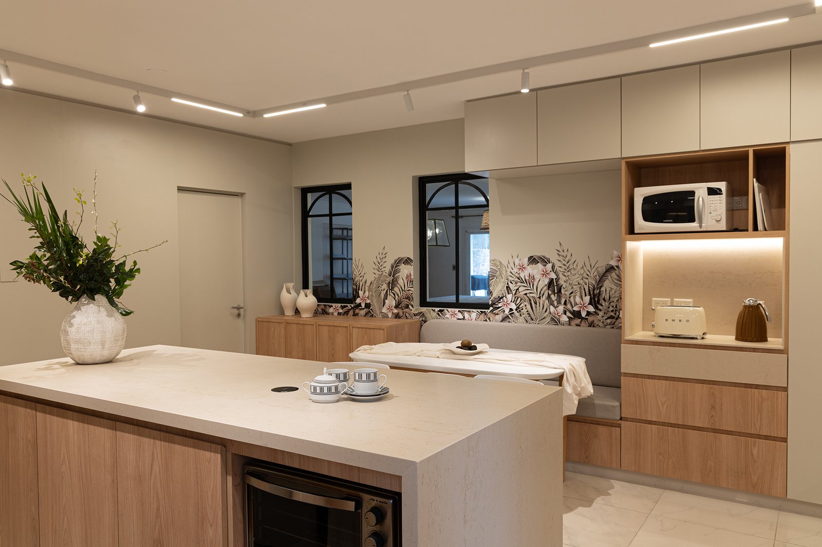 Cocina moderna con isla, mural botánico y detalles en madera clara — proyecto Ortega y Gasset - Estudio PLATS, por Gaby Alfonso, en Ortega y Gasset 1900