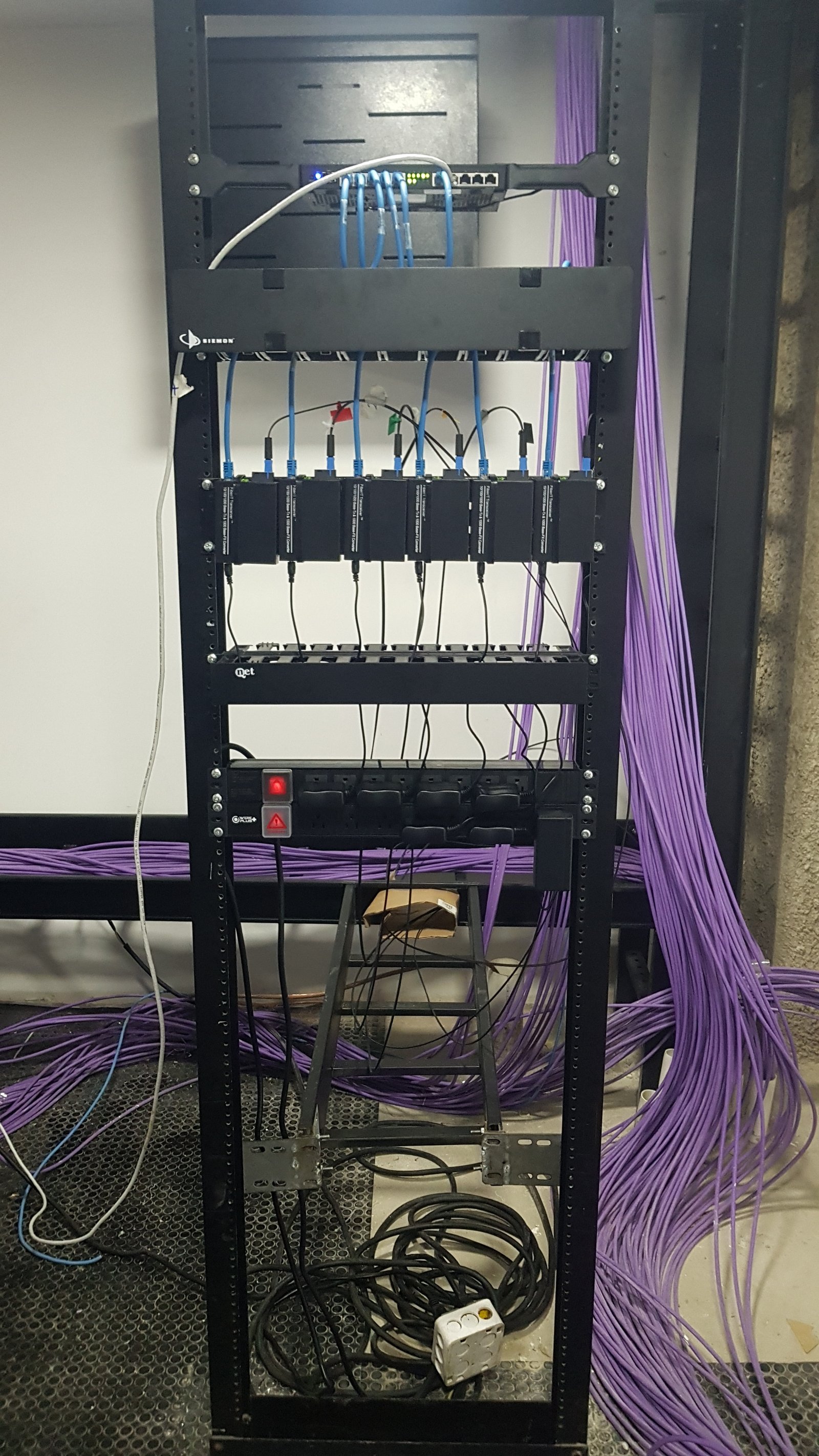 Rack de servidores con muchos cables en un espacio industrial — proyecto Montajes eléctricos en oficinas Comerciales , por Mantenimientos Comerciales Leon , en Buenos Aires