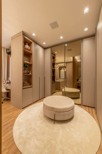 Vestidor contemporáneo con espejo de cuerpo completo y puf central beige — proyecto Projeto Destaque Club&Casa, por Andrea Carvalho Arquitetura