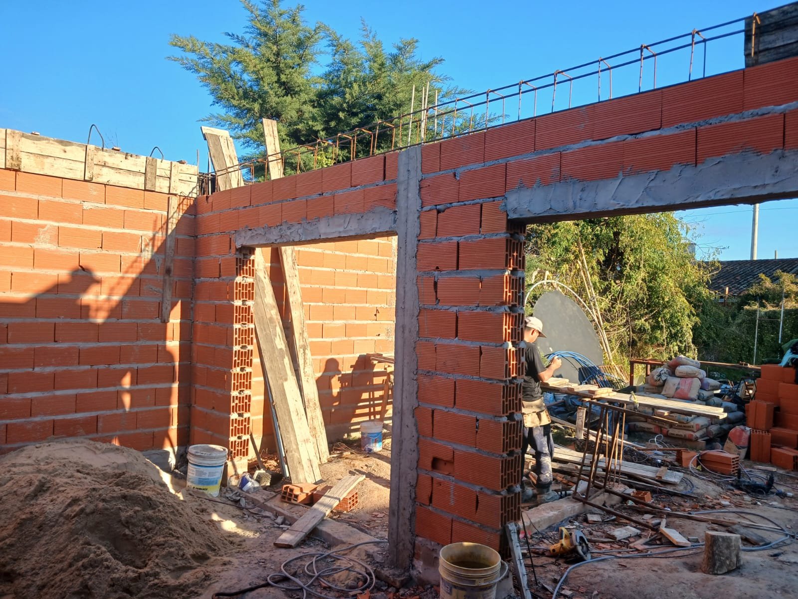 obra en construcción con ladrillos y obrero — proyecto Quincho G+G, por Sep Arquitectura , en La Plata