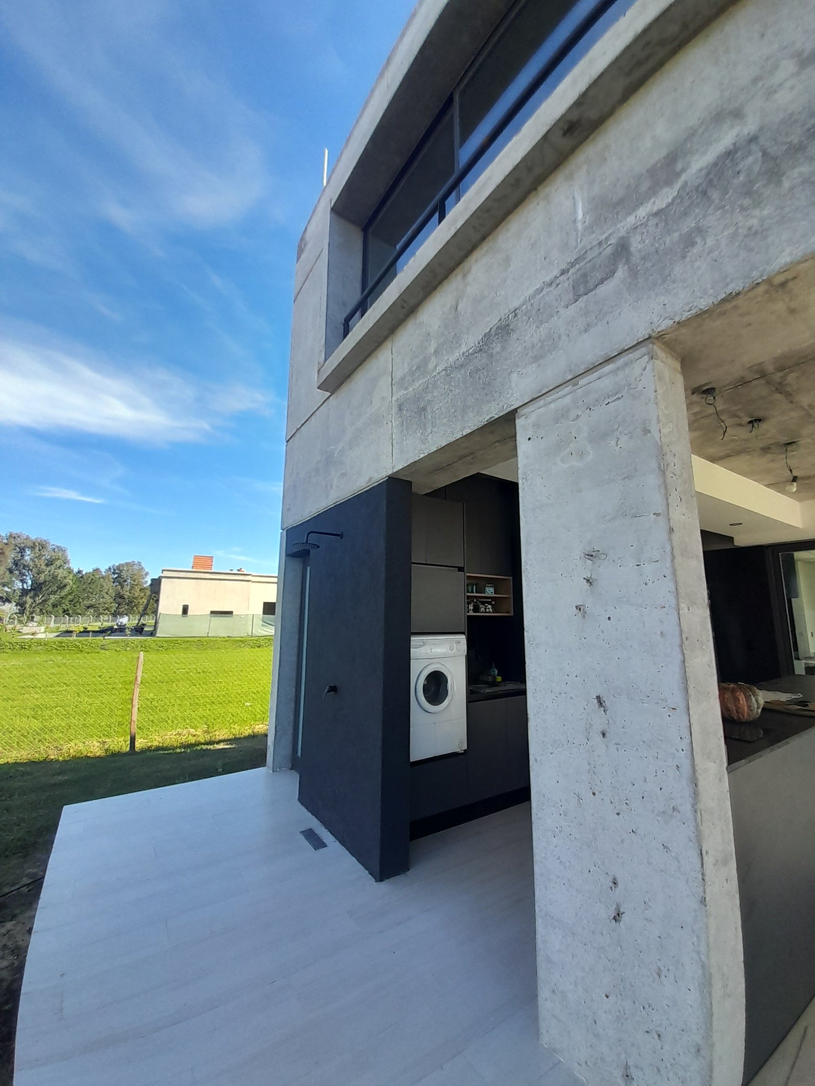 Fachada moderna de concreto visto con lavadero exterior — proyecto Puerto Nizuc, por Estudio Fernandez Long & asoc., en Au Dr. Ricardo Balbín km 31.5