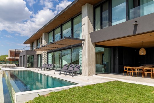 Casa moderna con pileta infinita, deck de hormigón y jardín verde — proyecto Obra Casa Belair, por lifecycle, en B1648 Tigre