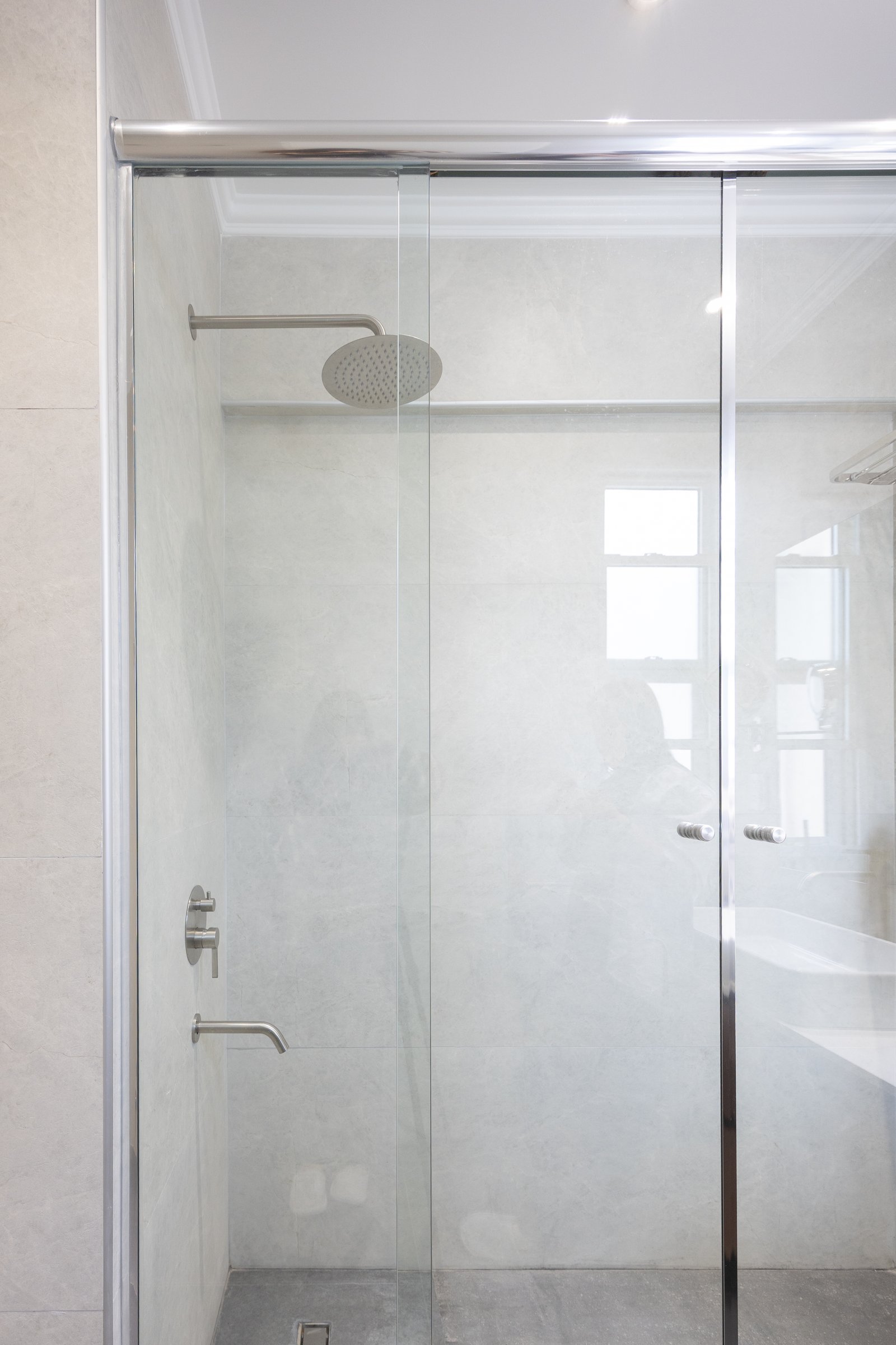 Baño moderno con ducha amplia y mampara de vidrio sin marco — proyecto Balvanera, por Martina Kleinert, en C1032 Buenos Aires