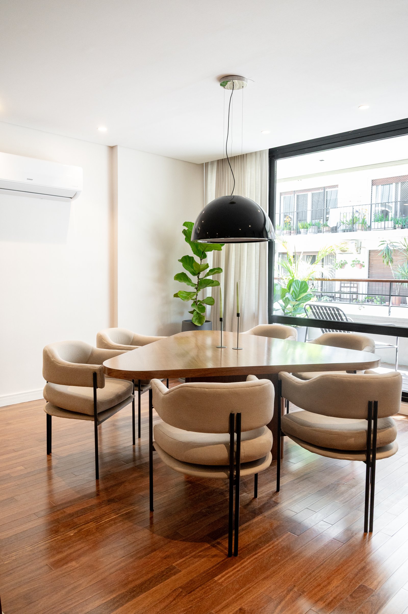 Sala de jantar moderna com mesa oval de madeira e cadeiras estofadas — projeto MONTEVIDEO, por AB ARQUITECTURA, em Recoleta