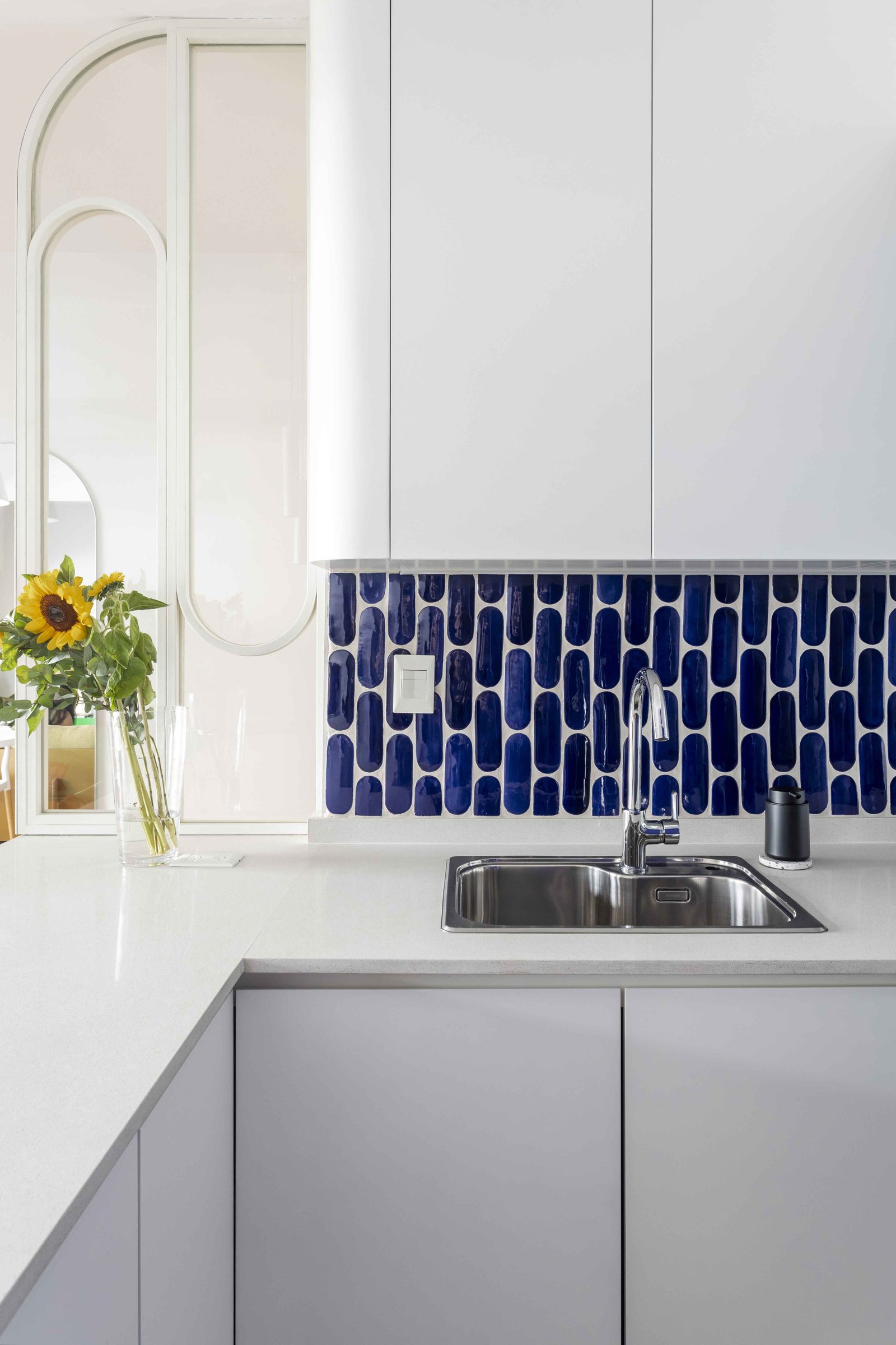 Cozinha moderna com azulejo azul em pílula e janela em arco — projeto Julián Alvarez, por Bouré Studio, em Palermo