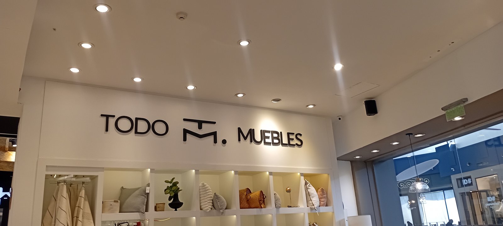 Loja "Todo M. Muebles" com prateleiras iluminadas e fachada de vidro — projeto TODO MUBLES LA BARRACA, por Yamil Cerna, em Dorrego Mendoza
