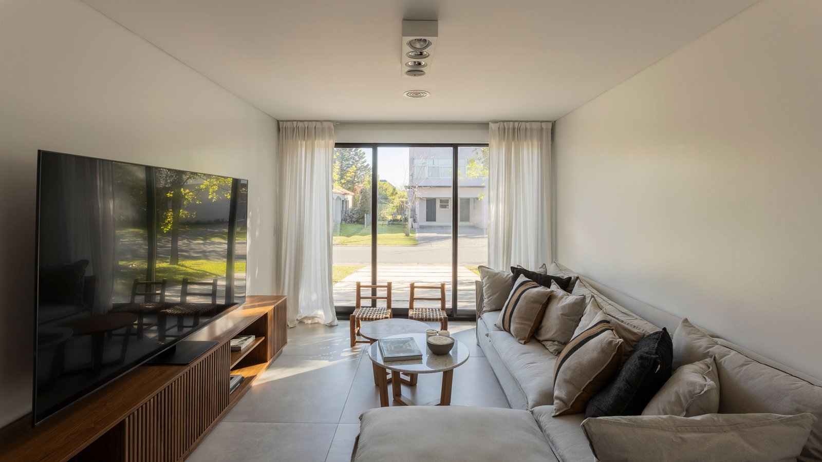 Sala de estar moderna e espaçosa com muita luz natural — projeto REFORMA GDLT, por Rastro Estudio, em Nordelta