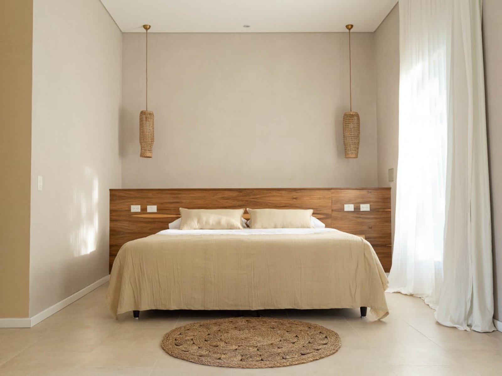 Dormitorio moderno con cama grande, luces colgantes tejidas y pared revestida — proyecto PROYECTO CASA BORA HOTEL, por ILVA, en Provincia de Buenos Aires