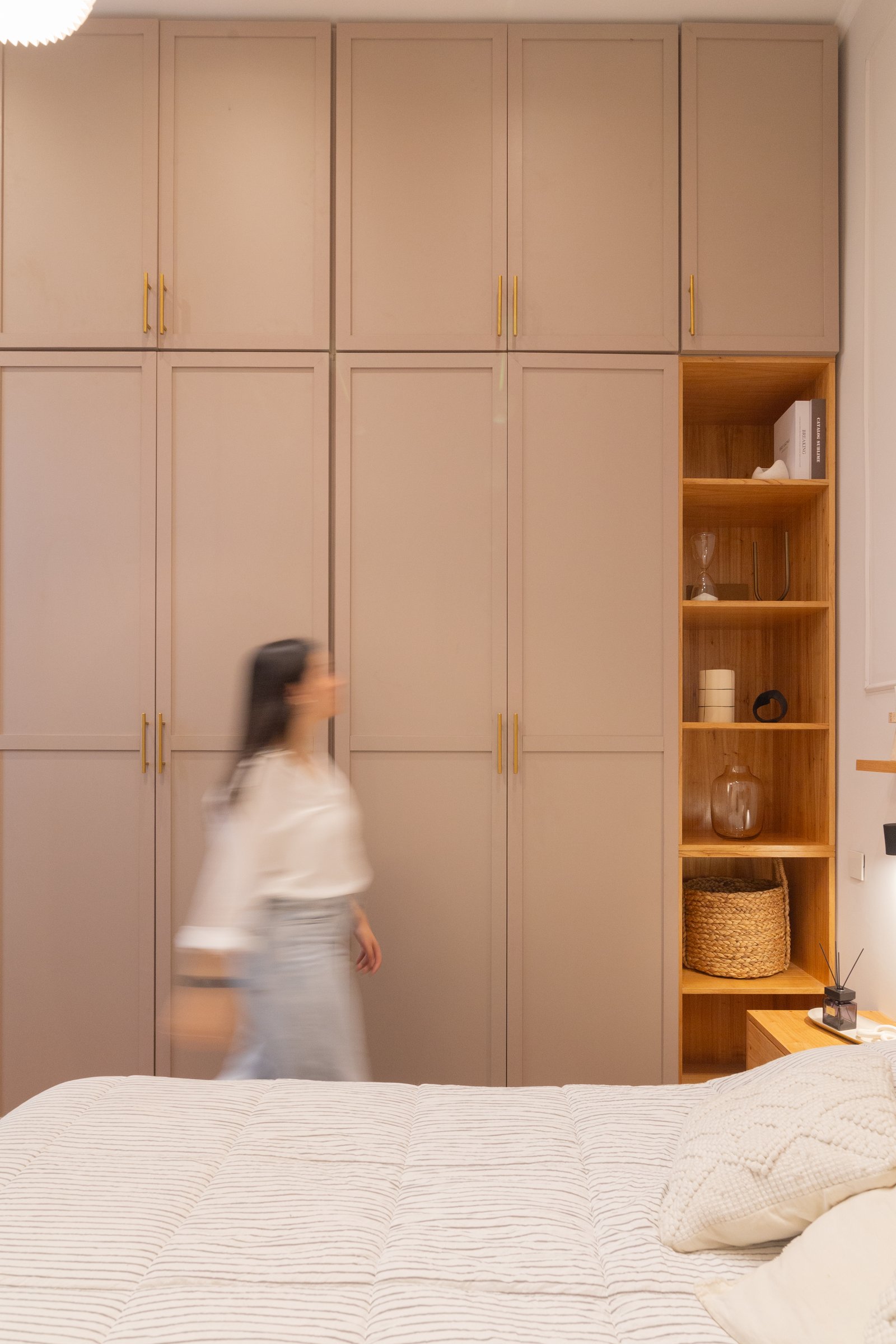 dormitorio minimalista con armario empotrado beige y cama a rayas — proyecto Anchorena, por Martina Kleinert, en Palermo