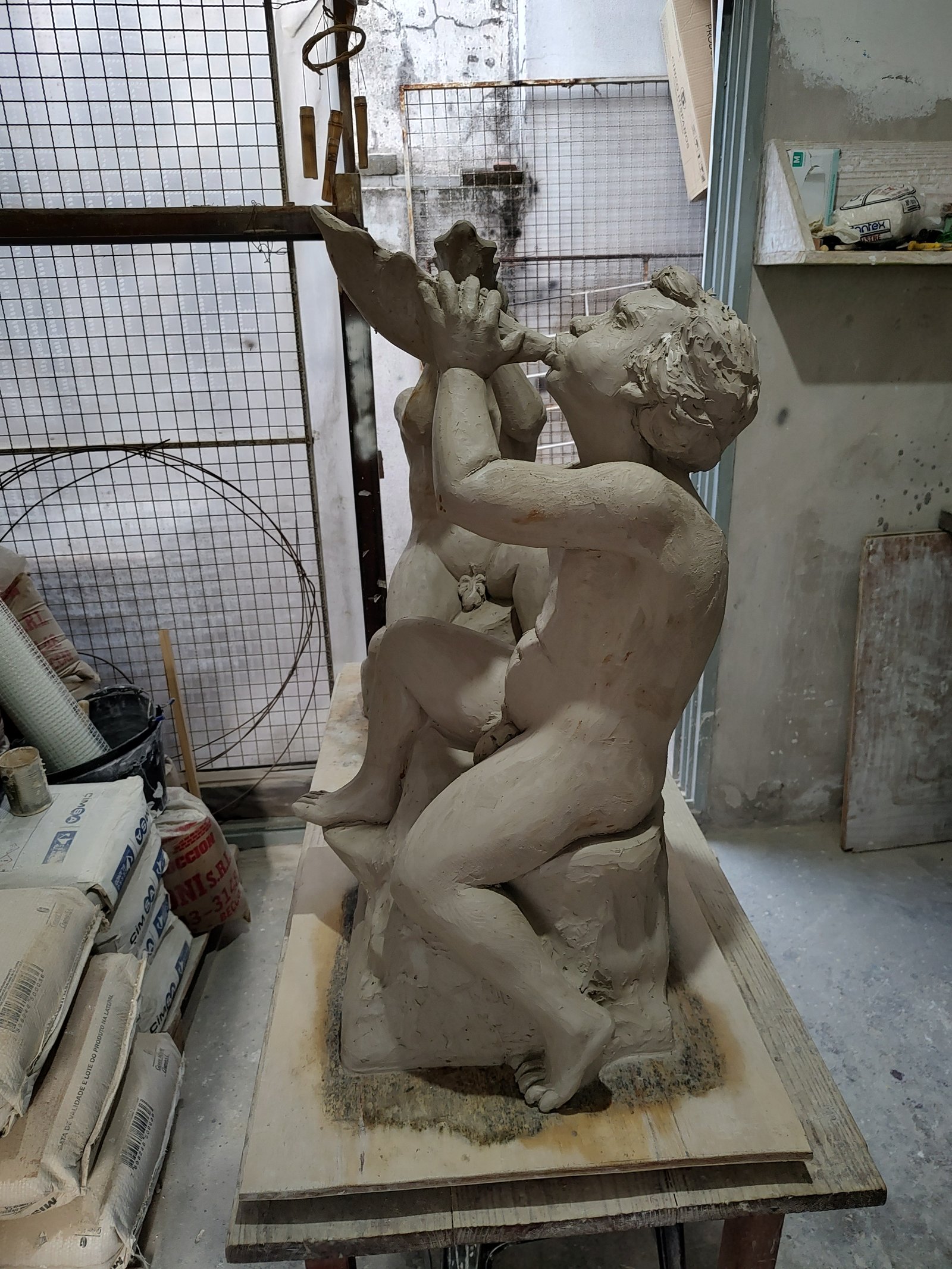 escultura de arcilla de niños tocando cuerno en estudio — proyecto Banco Central, por Arte Umbra, en Cdad. Autónoma de Buenos Aires