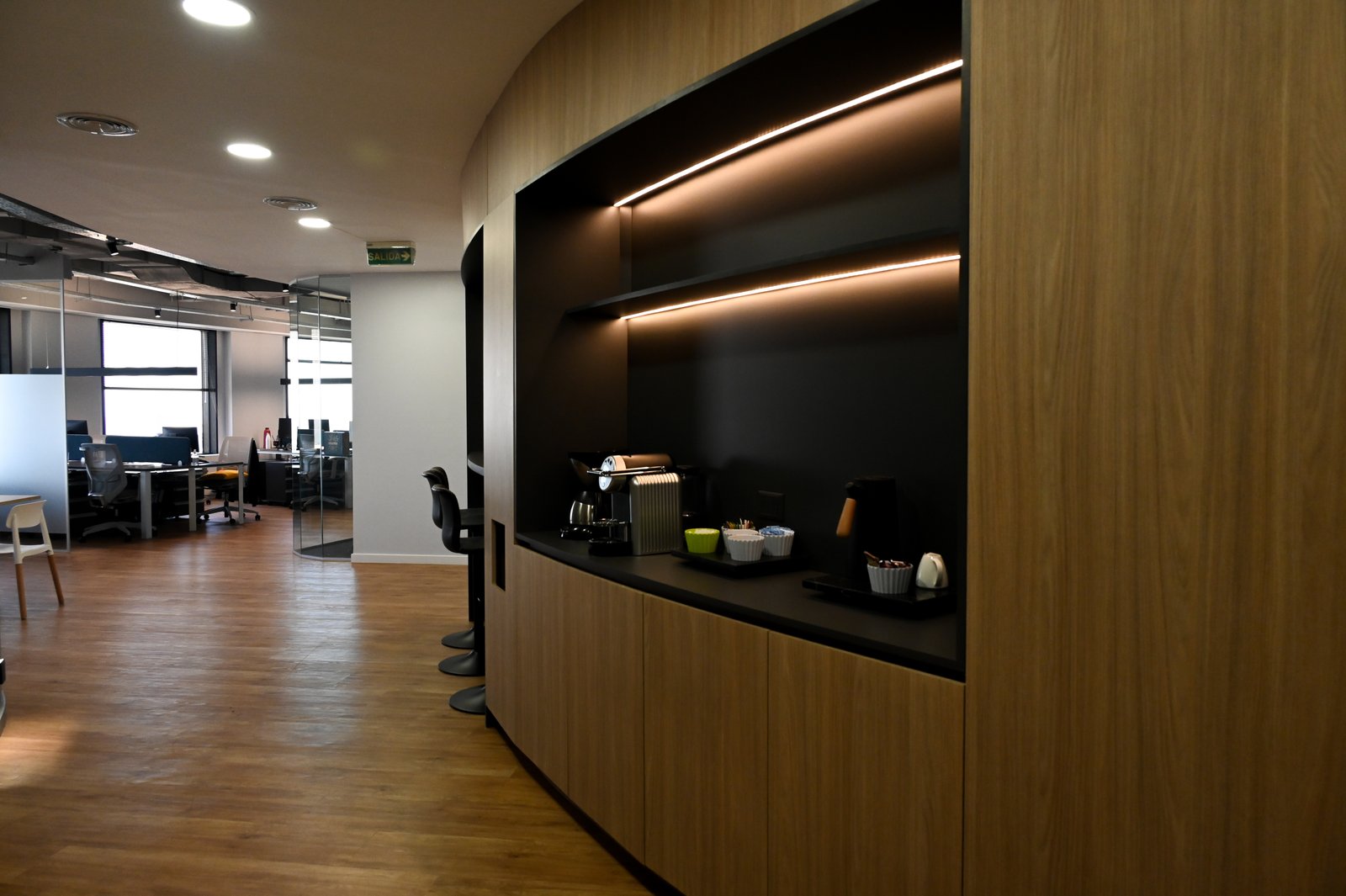 Oficina moderna con paneles de madera y luz indirecta — proyecto Oficinas UIP, por cromo., en Retiro