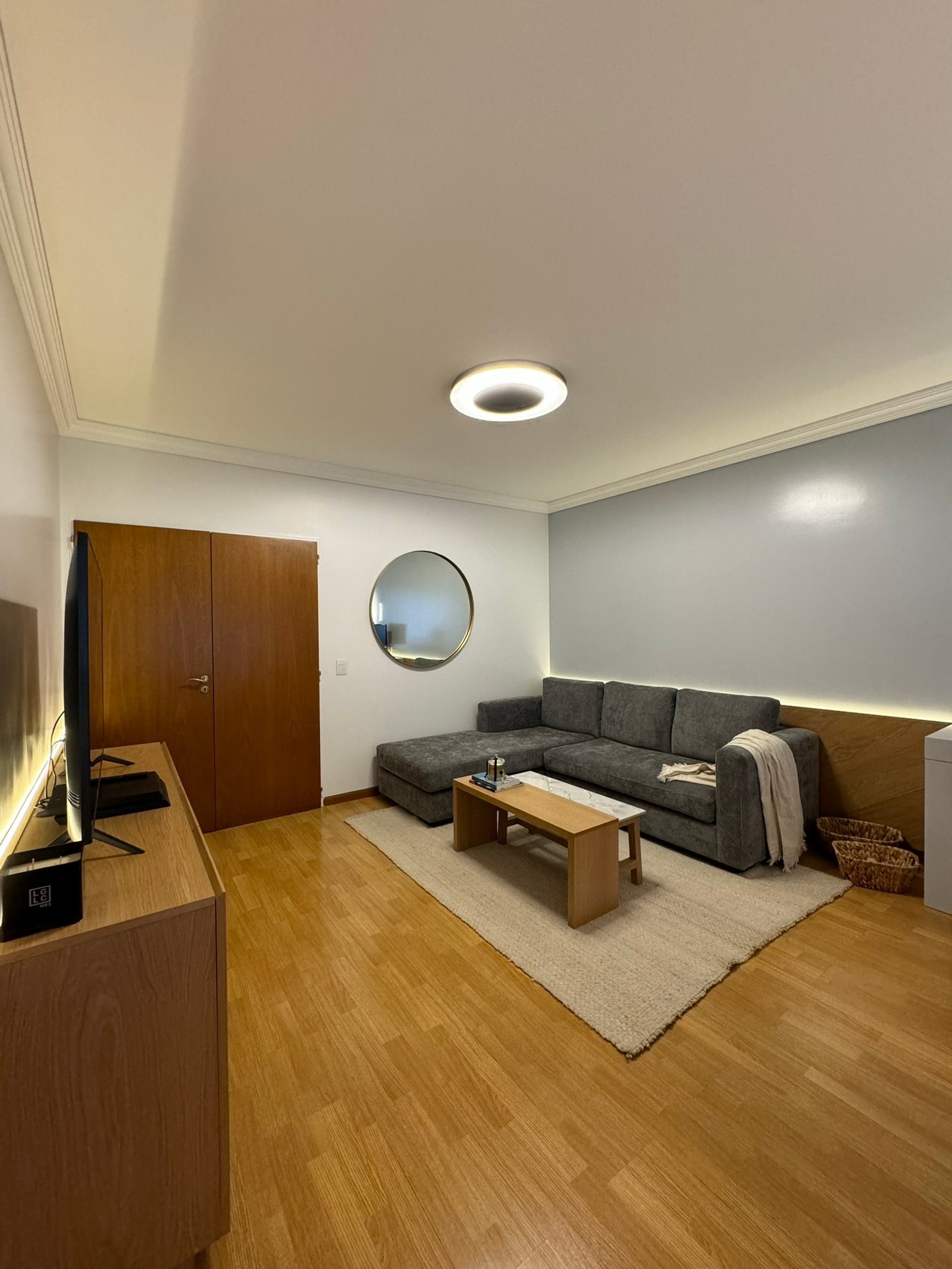 Living moderno con sofá seccional gris y mesa de centro de madera — proyecto Thompson, por MDBK Arquitectura, en Caballito