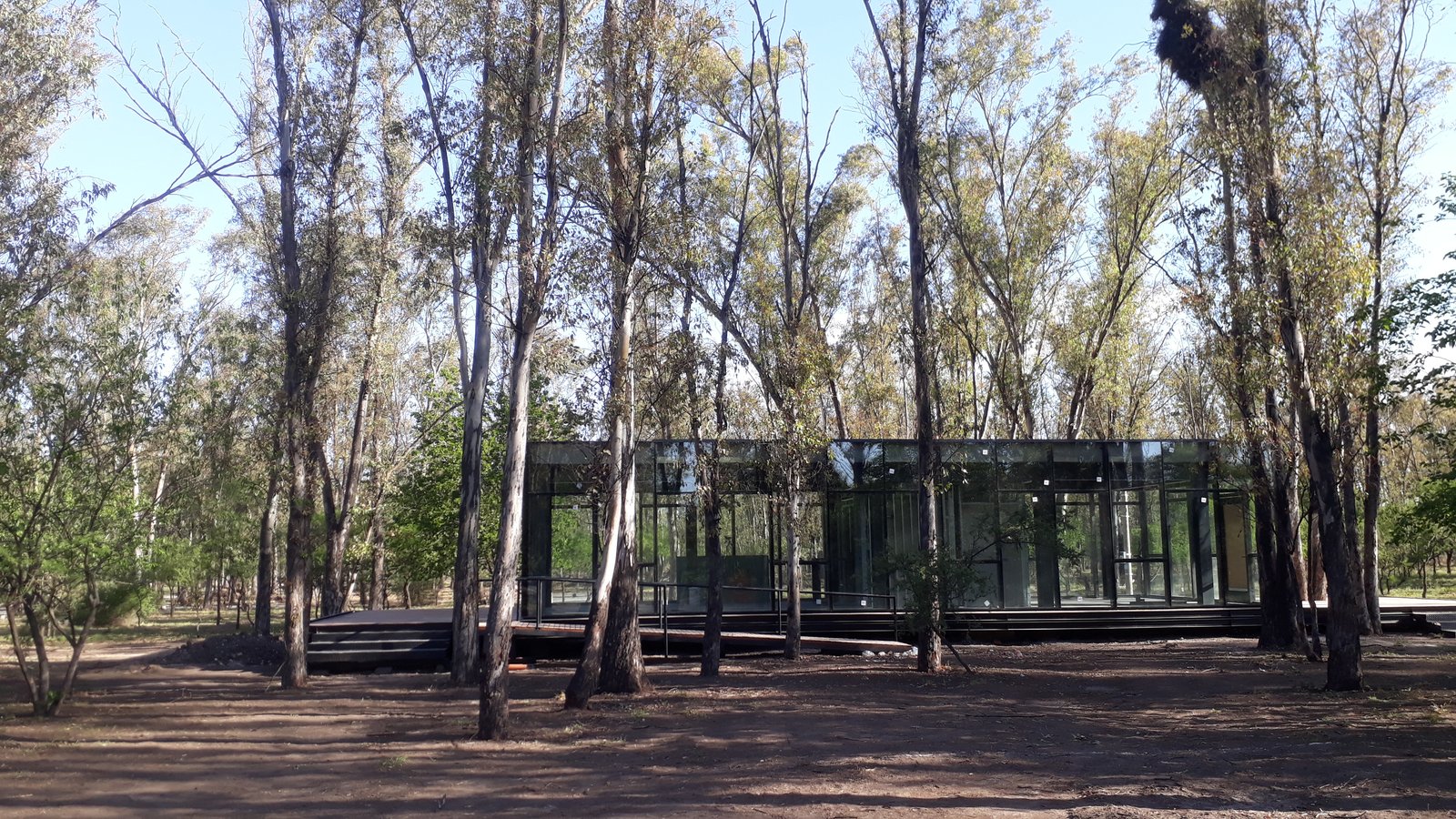 casa moderna con amplios ventanales en bosque — proyecto NUMA - Nuevo Malagueño - Yocsina Córdoba, por Estudio Rifahi, en Yocsina