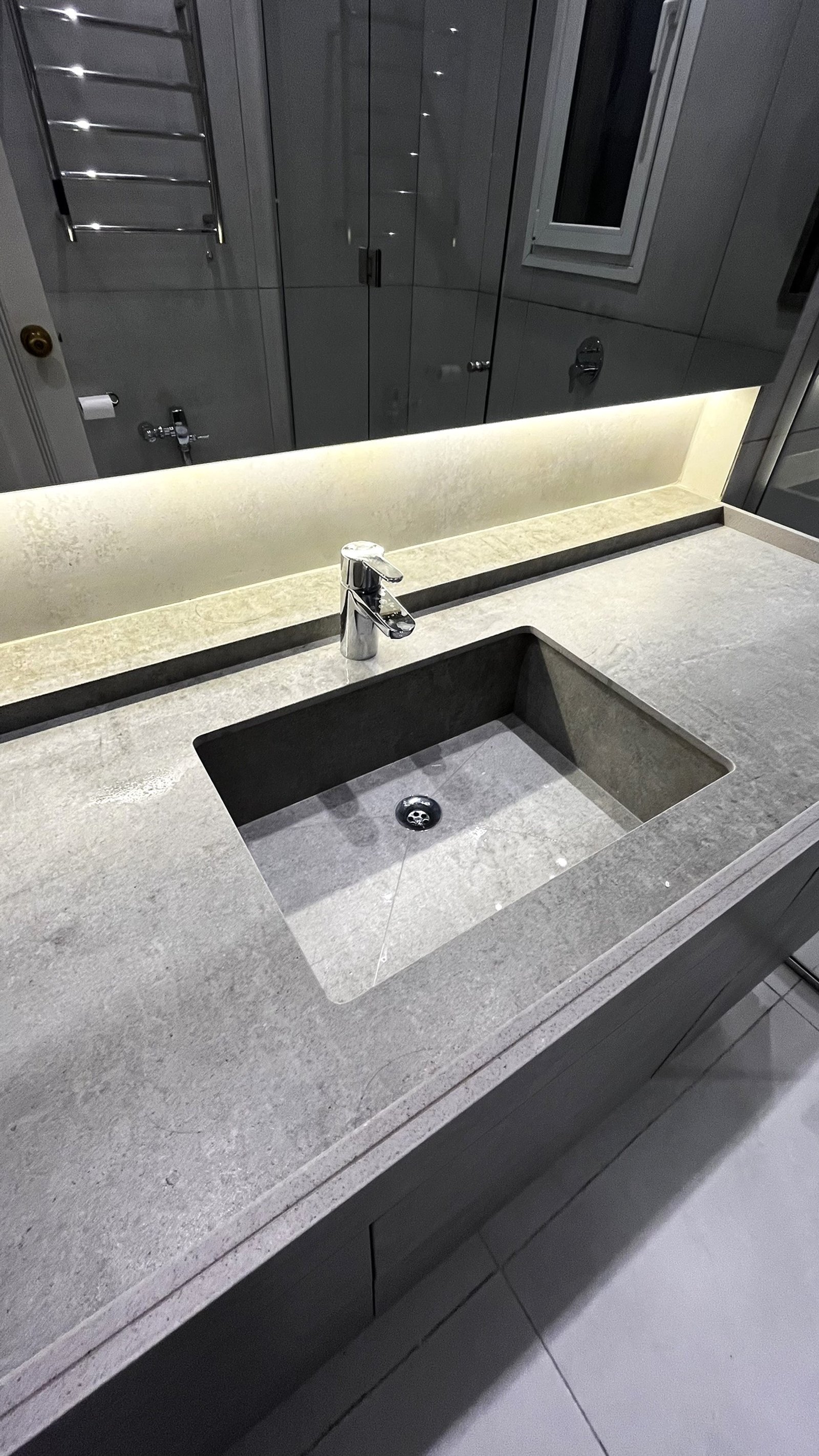 Baño moderno con lavabo integrado de piedra gris y grifería cromada — proyecto CASA CERRITO (German Salas arquitectura), por German Salas arquitectura - San Isidro, en Buenos Aires