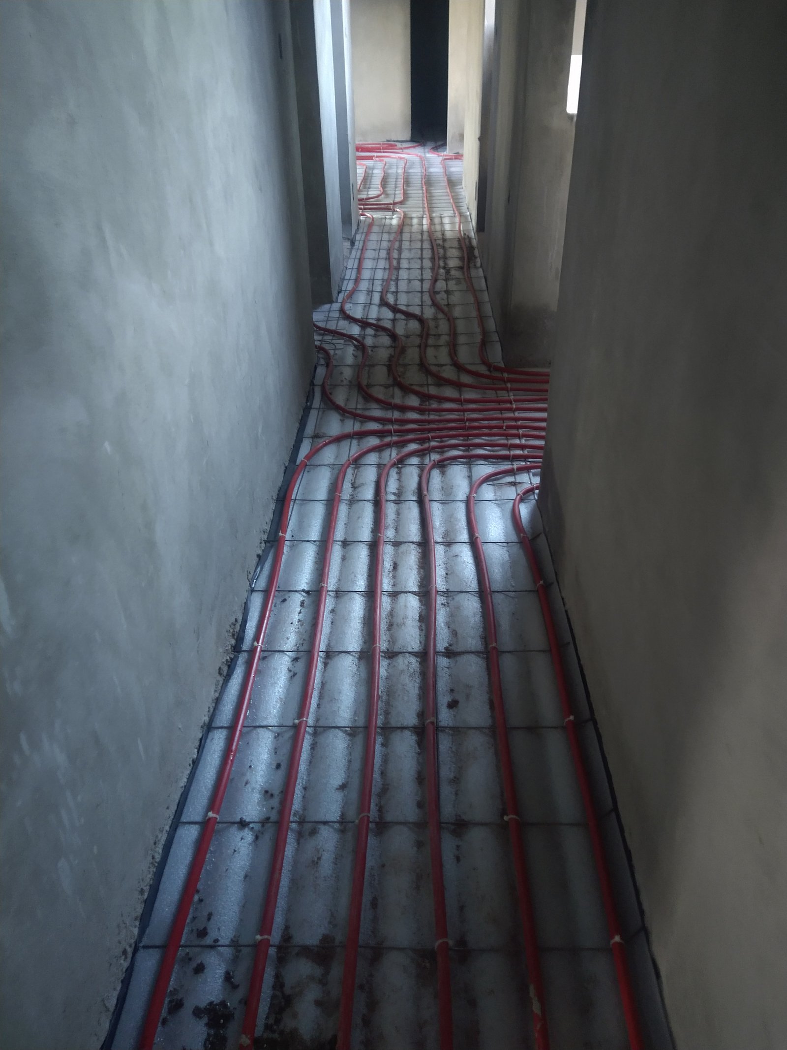 Corredor em construção com canos de aquecimento de piso — projeto Proyecto R-M, por TERROC, em Maipú