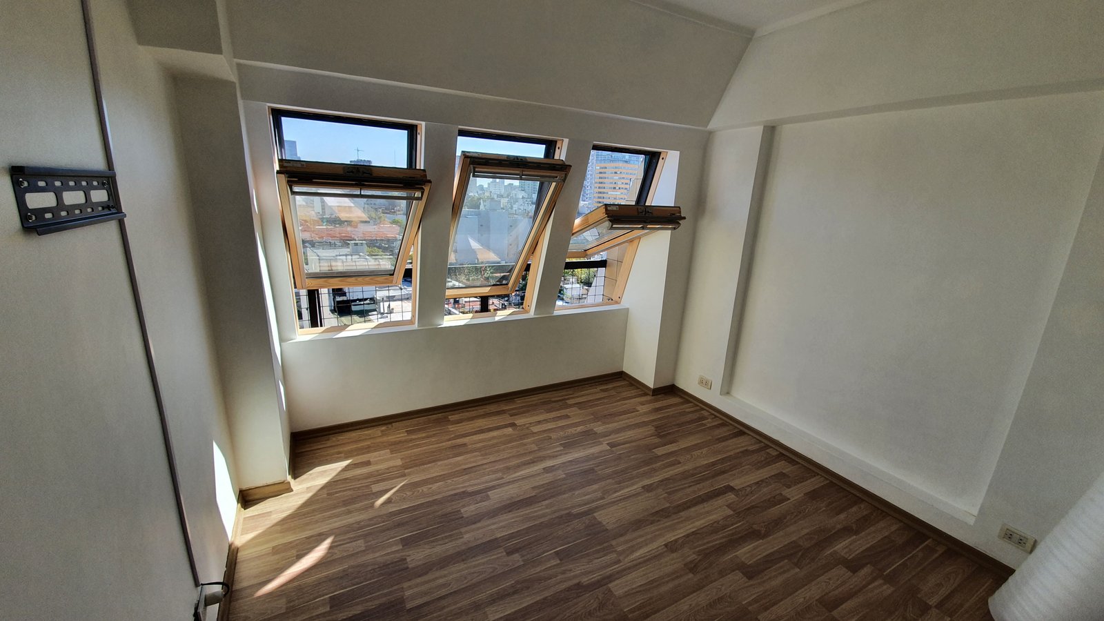 Sala de estar vacía con tragaluces inclinados y piso de madera — proyecto Aberturas DVH PVC - Reemplazo, por RenovArqui, en Palermo