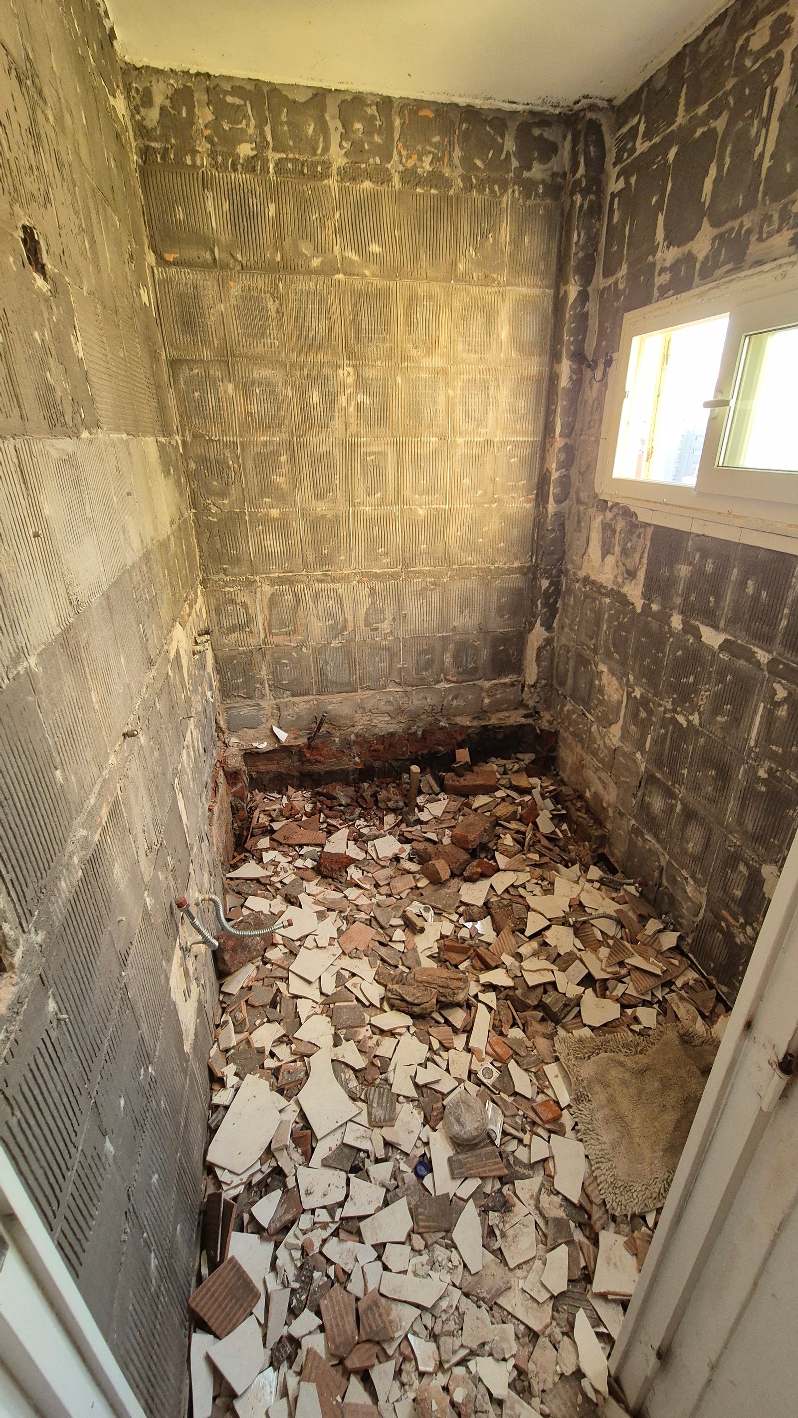 Baño en construcción con escombros y paredes descascaradas — proyecto Baño - Remodelación Soho, por RenovArqui, en Palermo