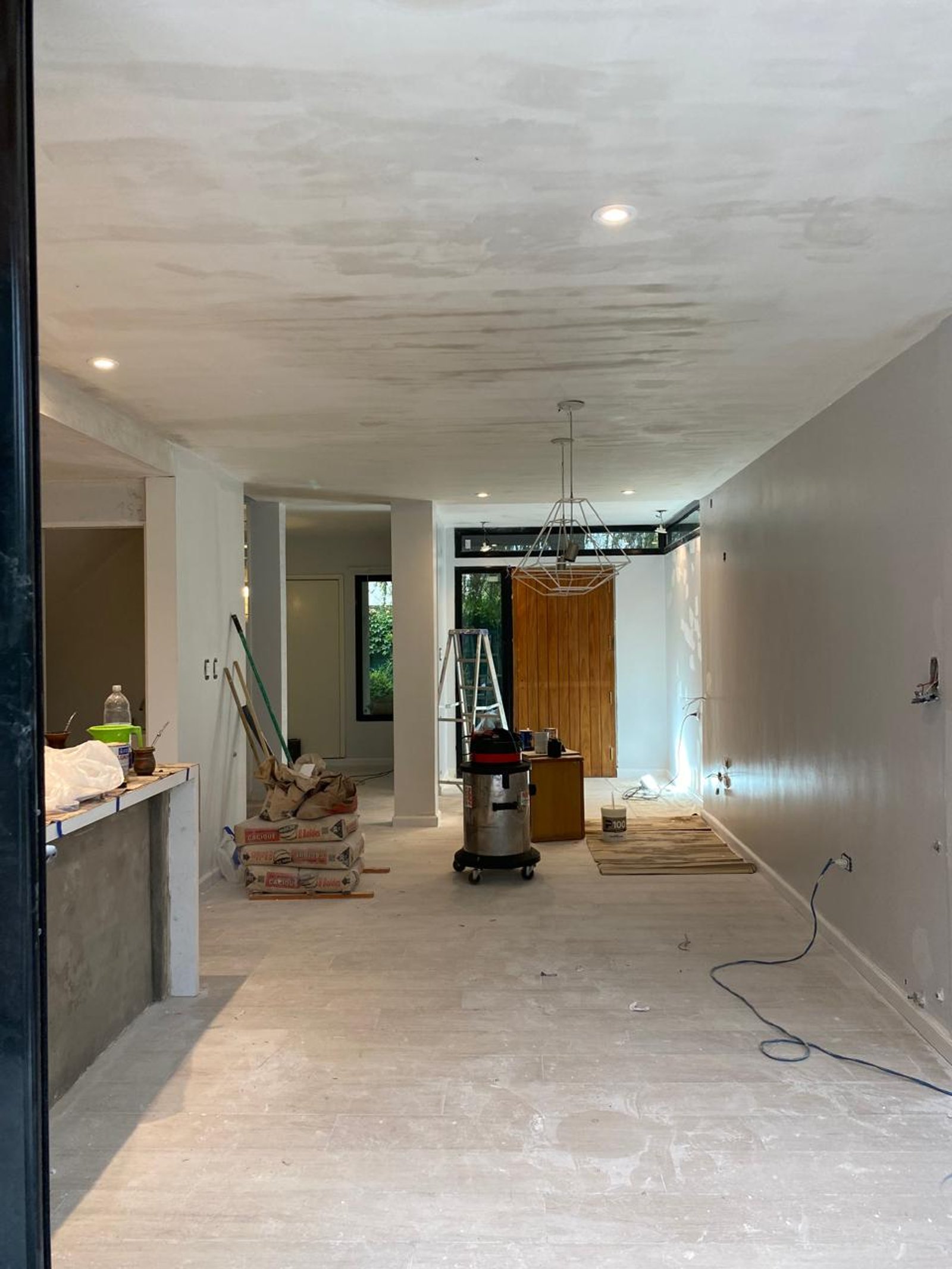 Interior en construcción con piso de cemento y techo de microcemento — proyecto Refacción dúplex CB, por arquitectura.JD, en La Plata