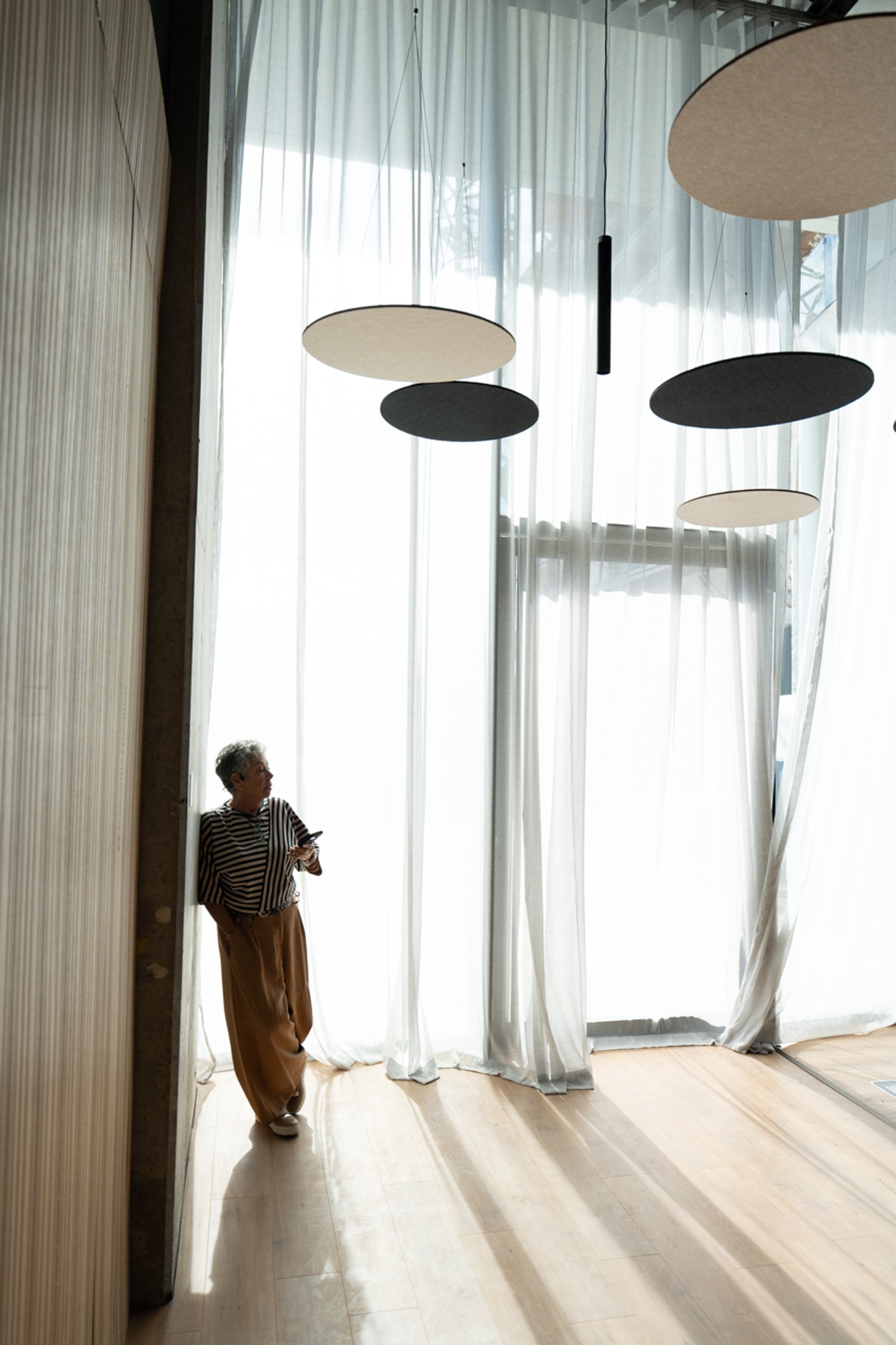 Espaço moderno com luzes ovais pendentes e cortinas translúcidas — projeto Auditorio LN, por KUPERDESIGN CONSTRUCCIONES SRL, em Buenos Aires